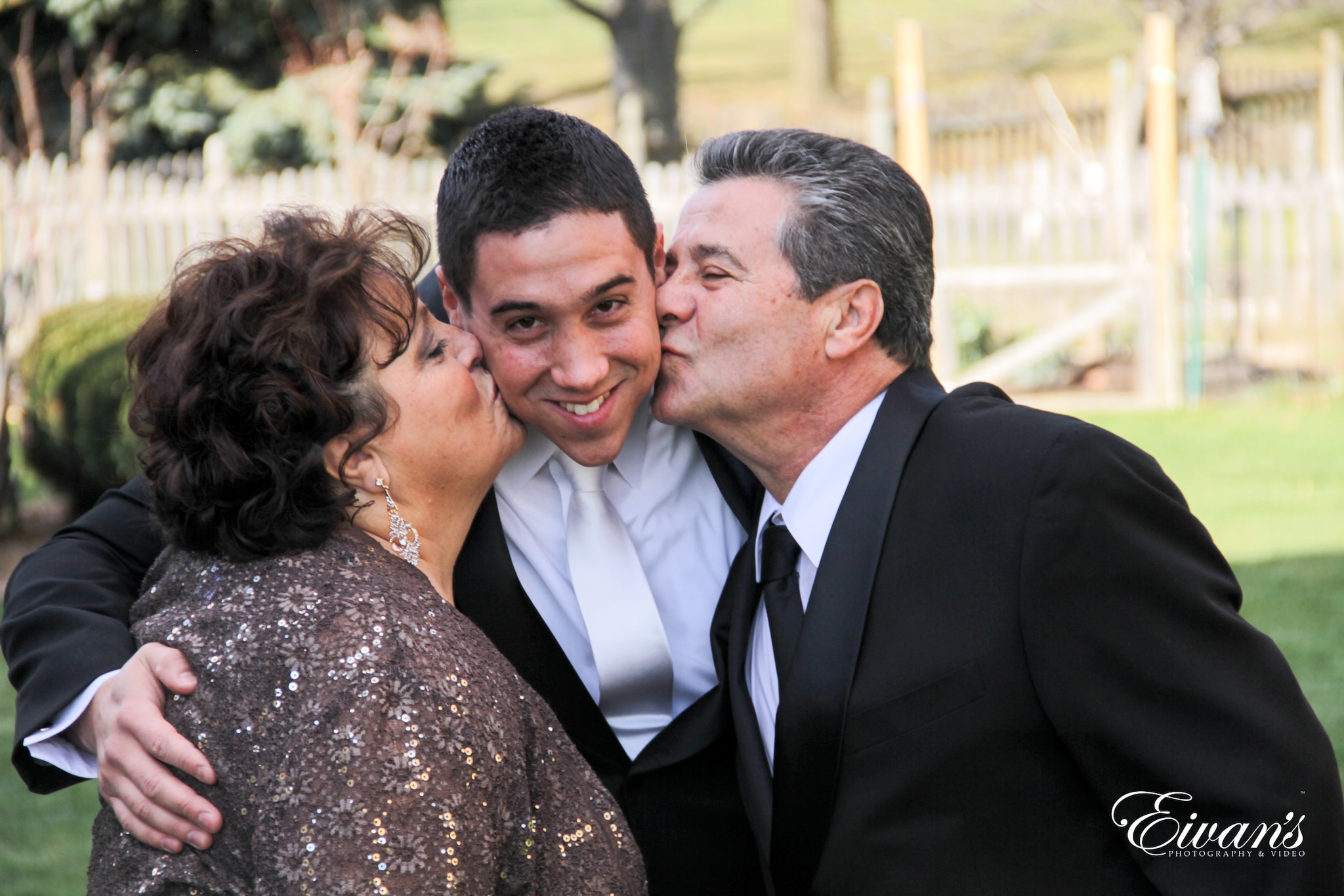 man in black suit kissing woman in brown floral dress