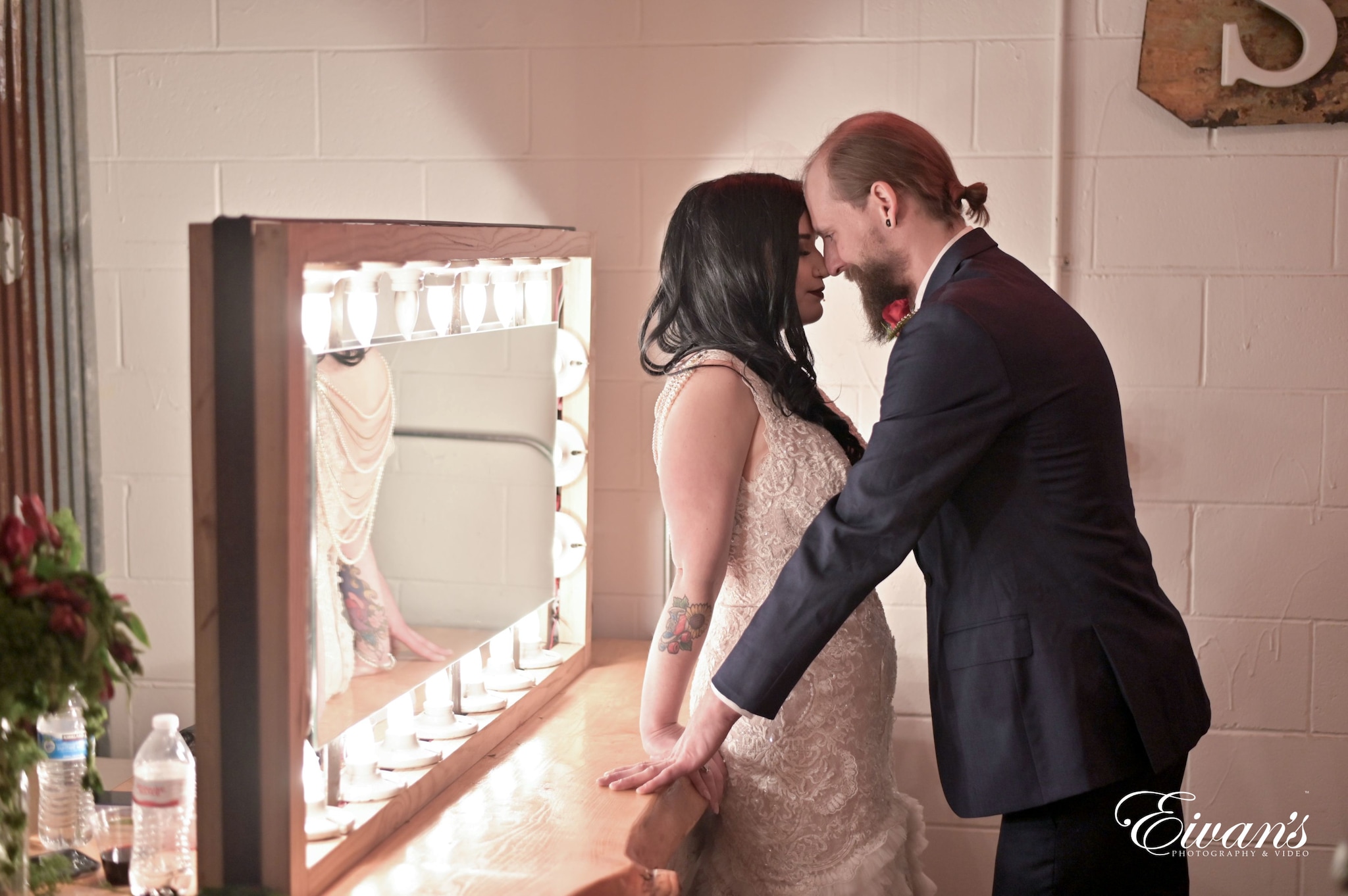 man in black suit kissing woman in white wedding dress