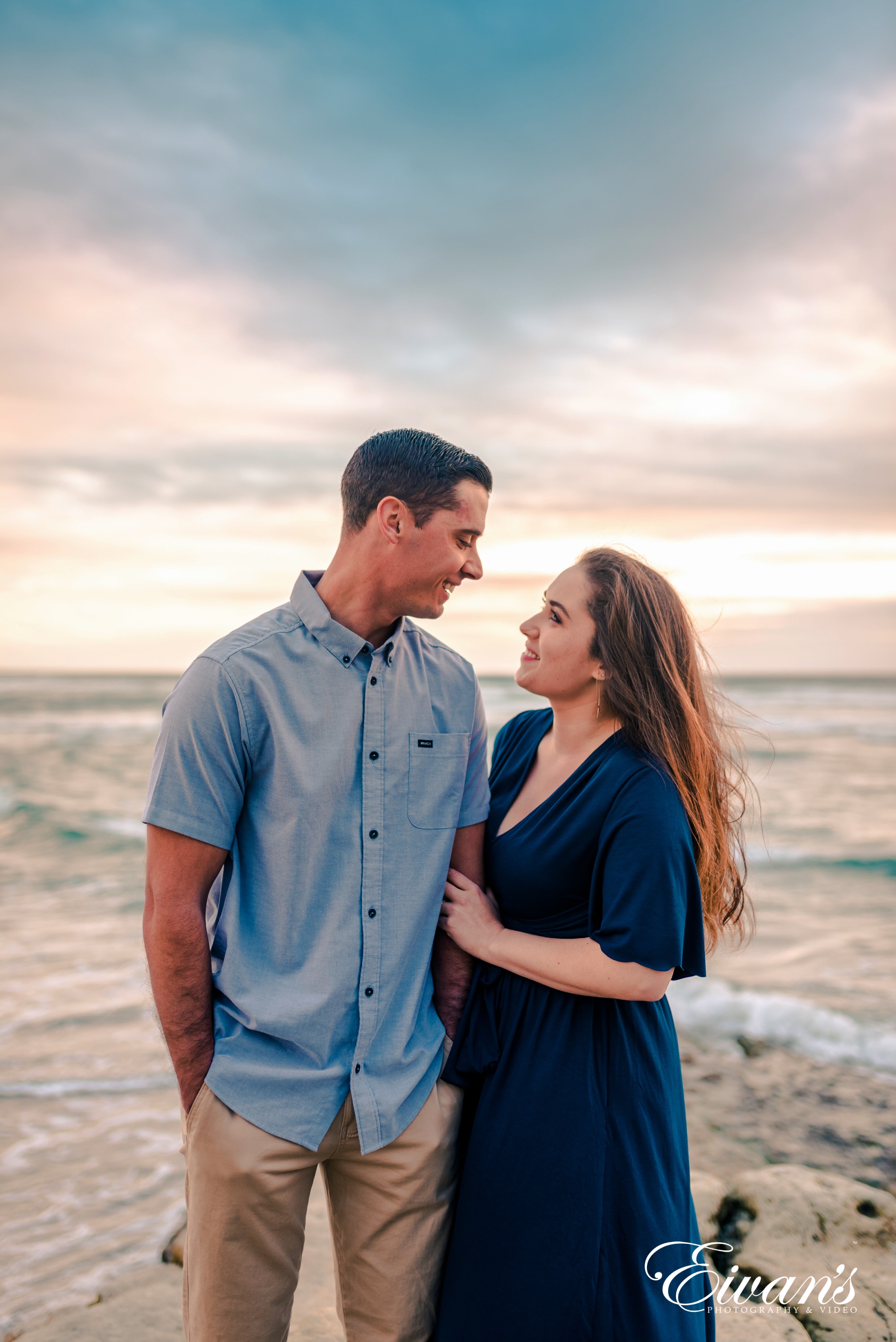 man in blue button up shirt standing beside woman in blue dress