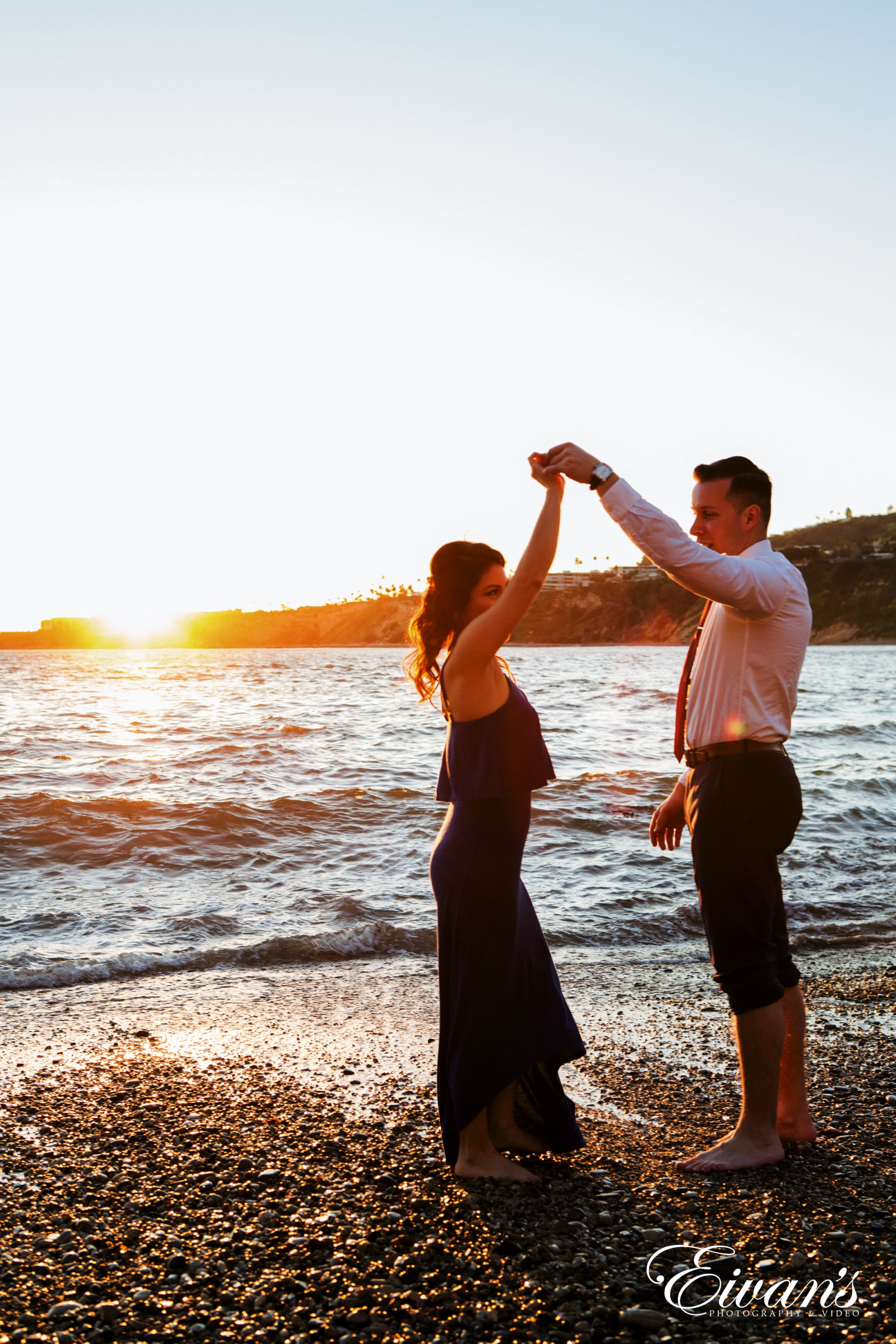 man and woman holding hands on beach during sunset