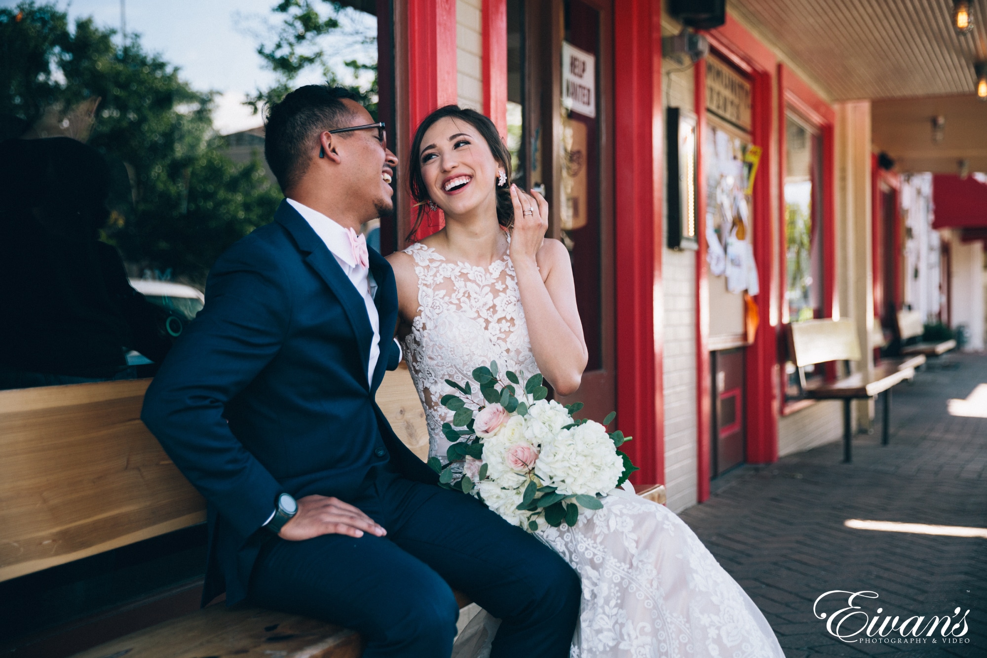 man in black suit sitting beside woman in white wedding dress