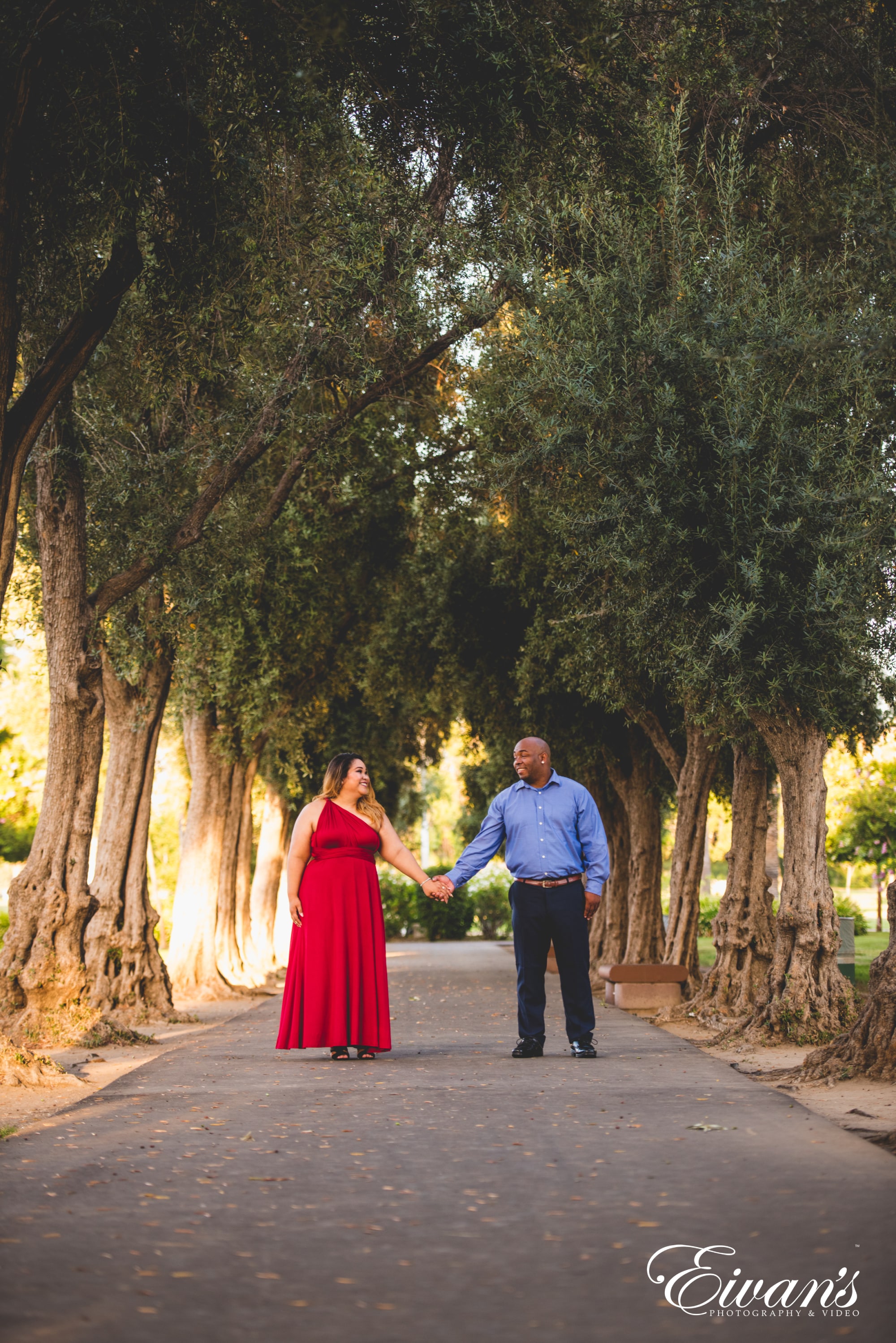 man and woman standing in front of green trees during daytime
