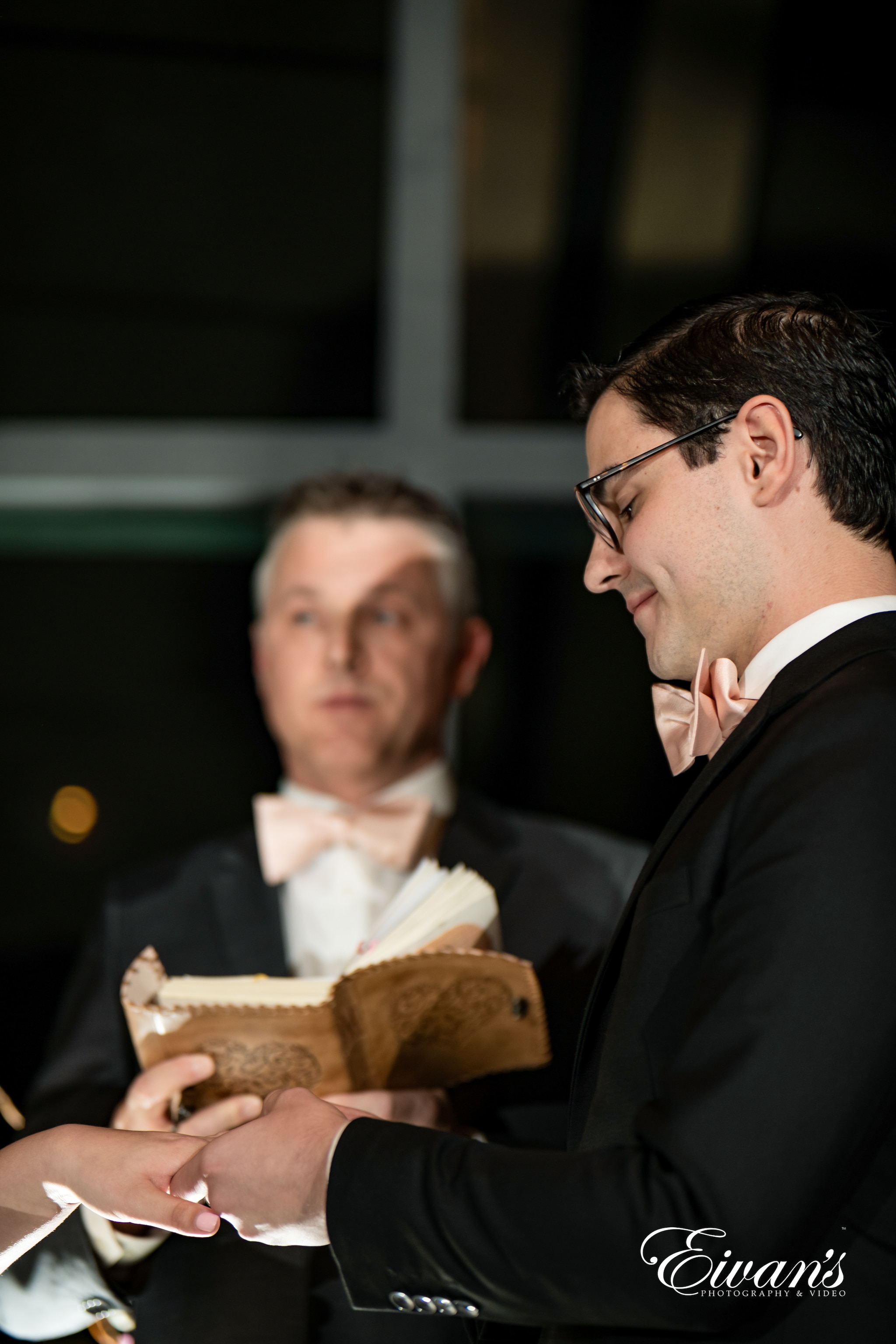 man in black suit holding brown wooden box