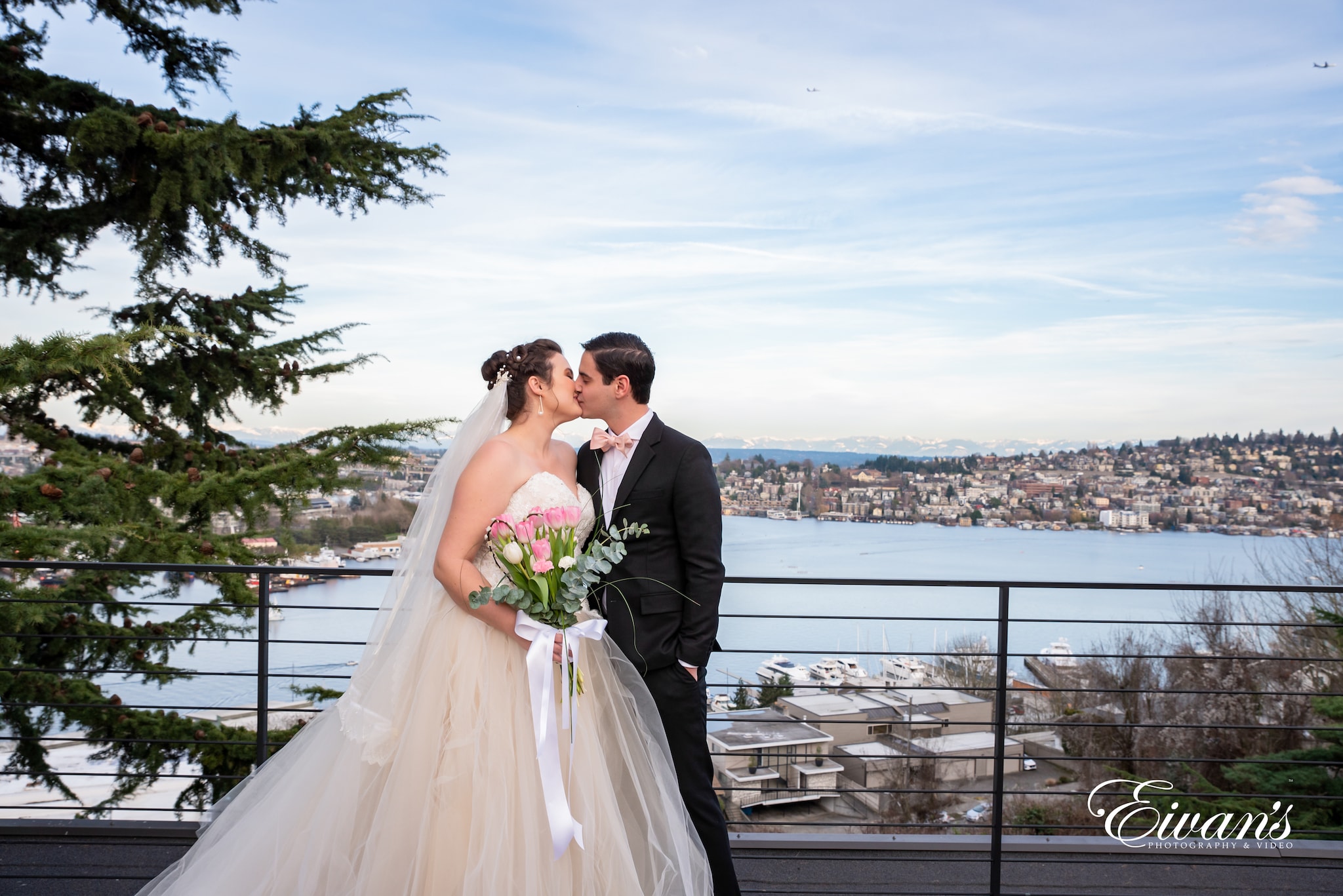 man and woman in wedding dress kissing on bridge during daytime