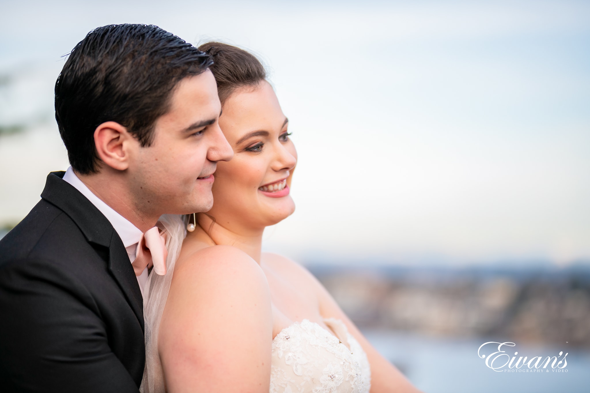 man in black suit kissing woman in white wedding dress