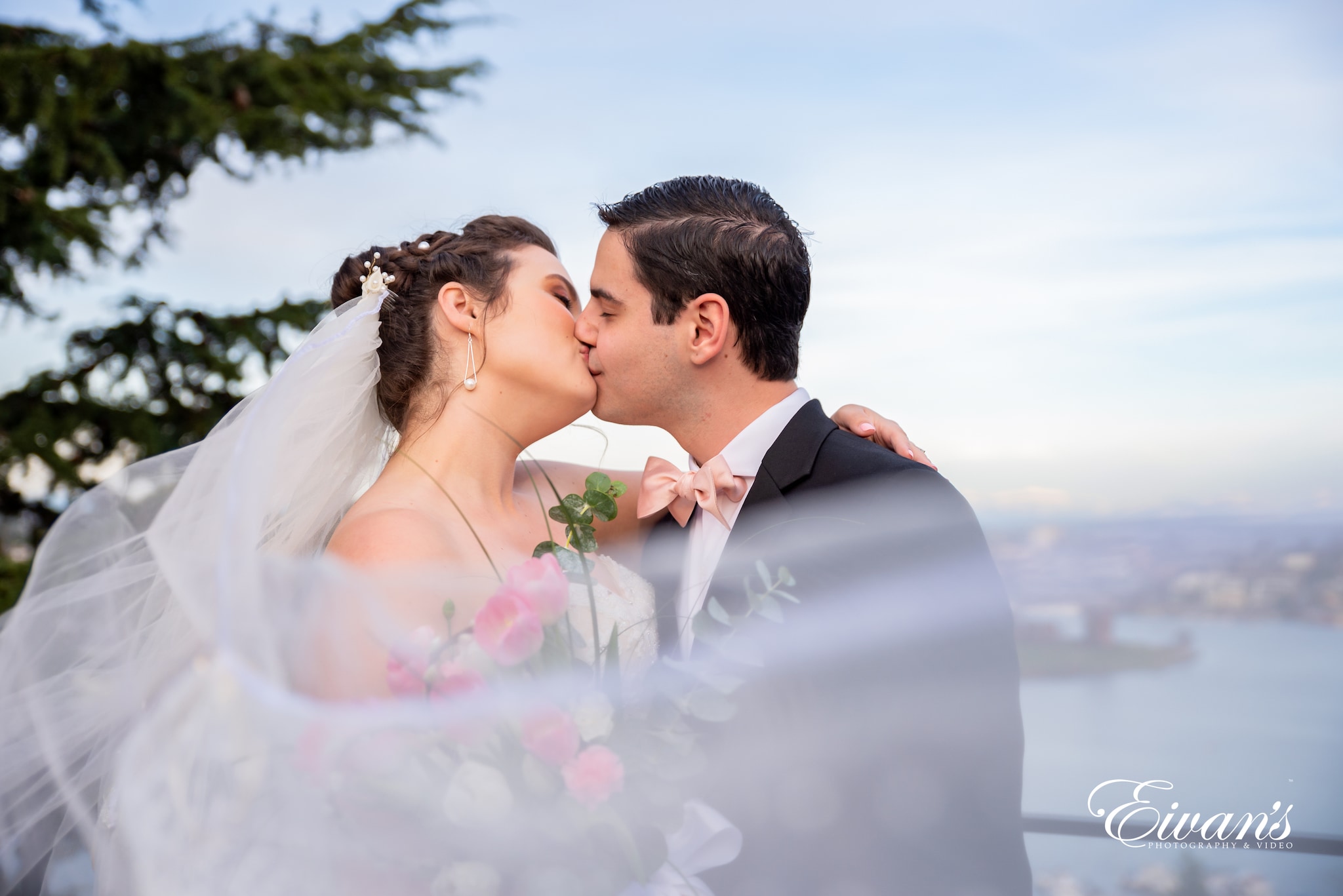 man in black suit kissing woman in white wedding dress