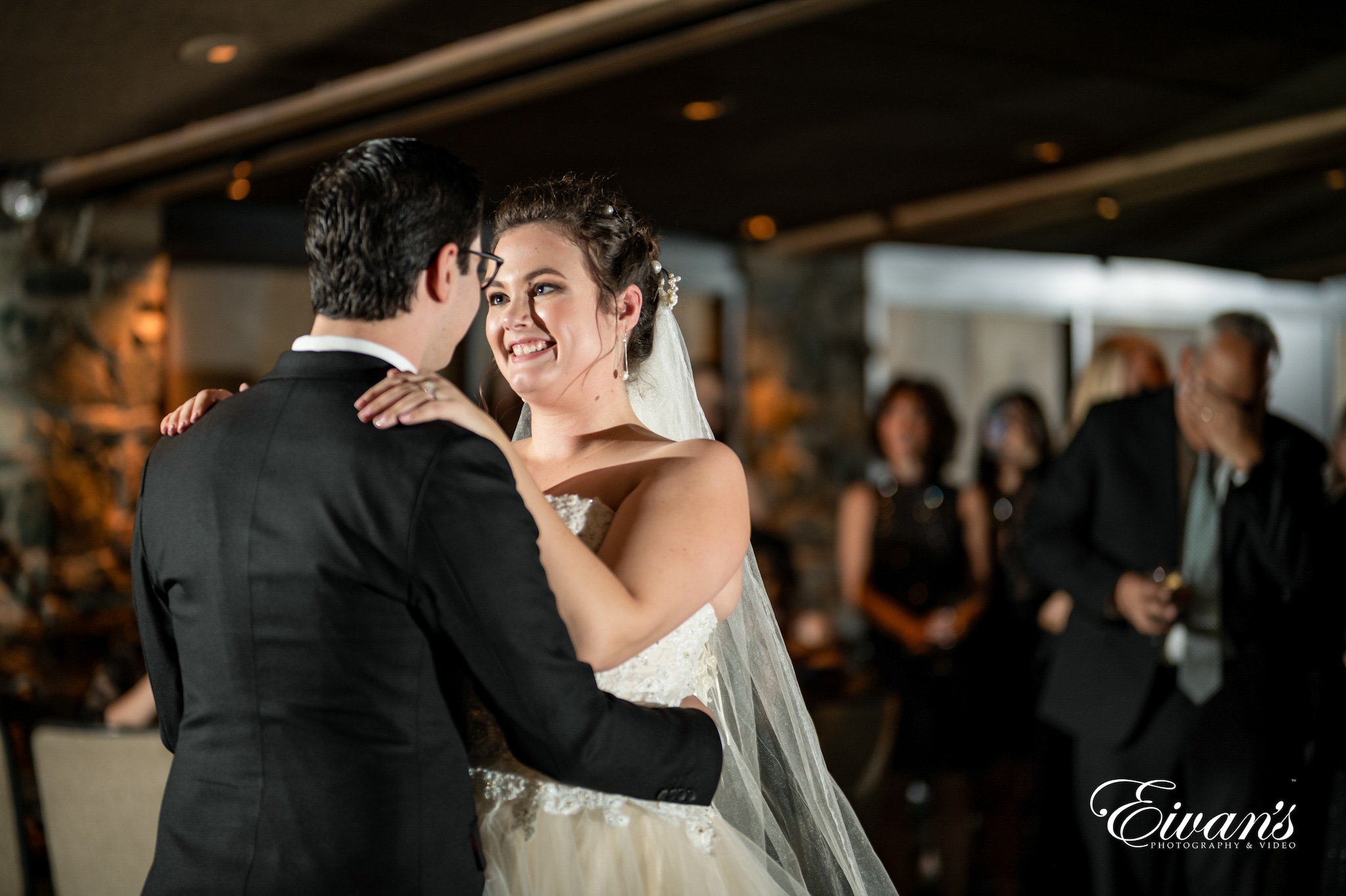 man in black suit kissing woman in white wedding dress