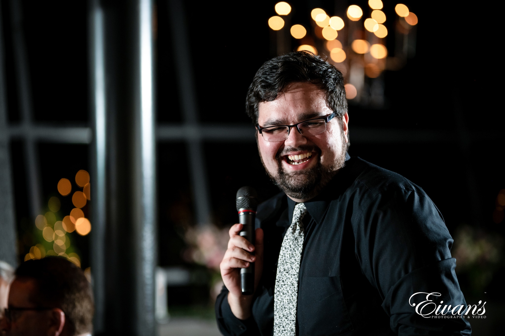 man in black dress shirt holding microphone