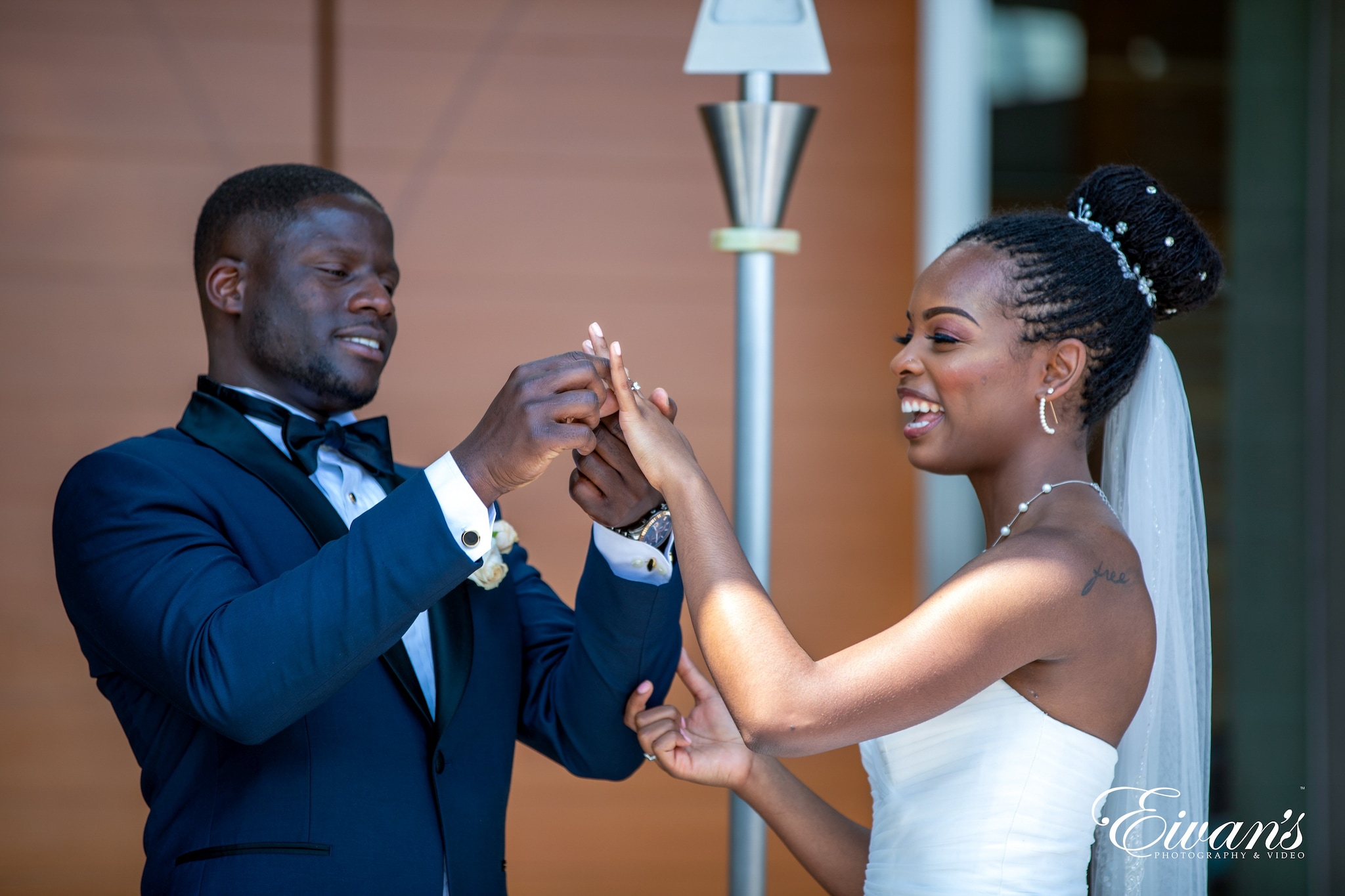 man in blue suit jacket holding woman in white tube dress