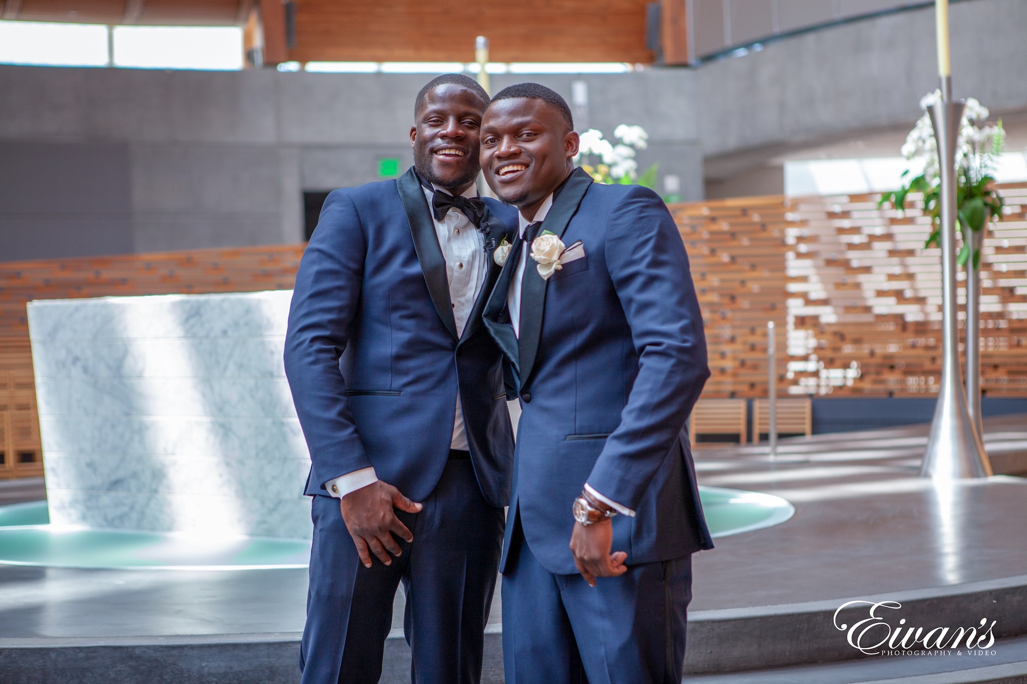 man in black suit standing near brown brick wall during daytime