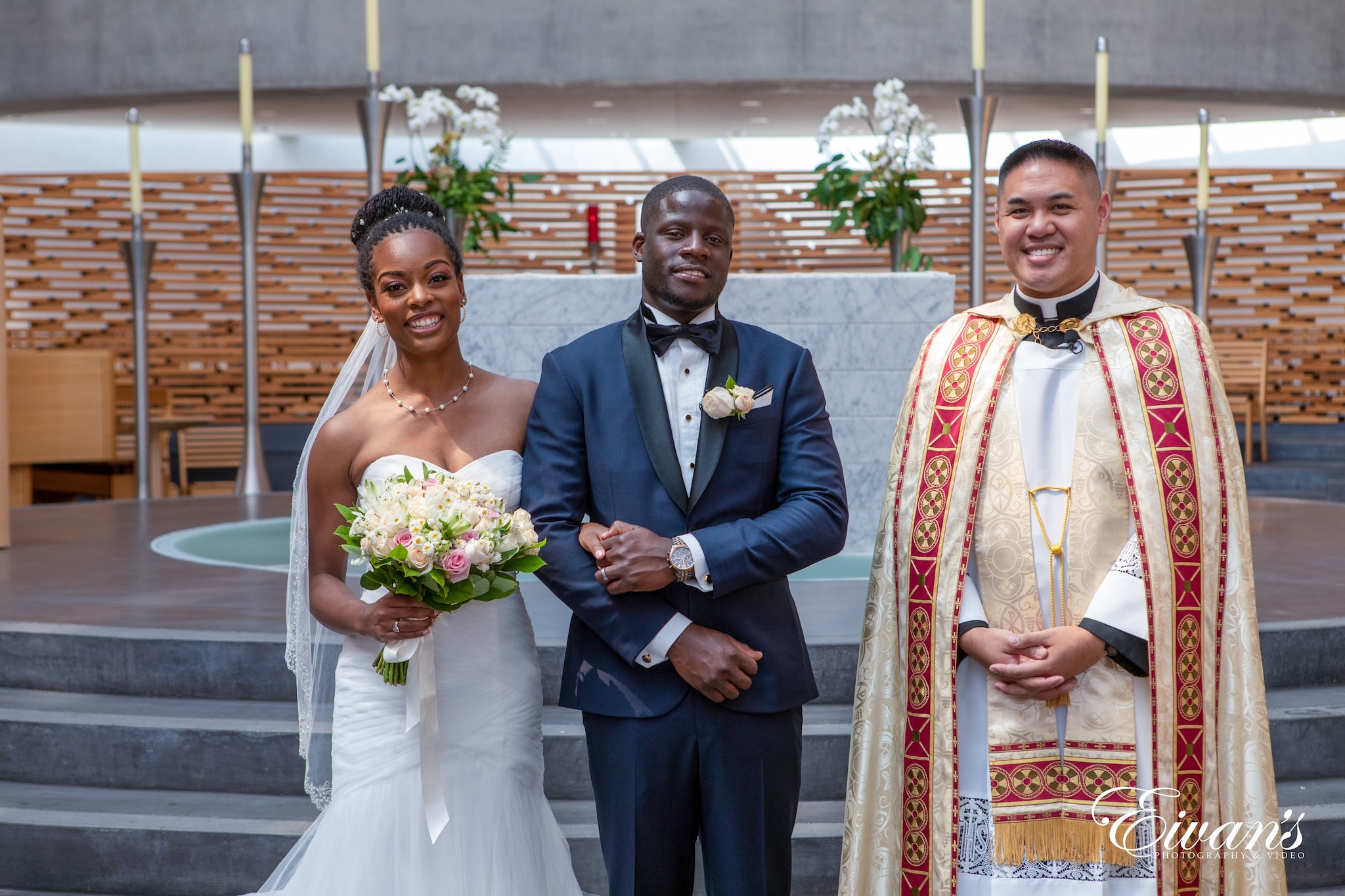 man in blue suit and woman in white wedding dress holding bouquet of flowers