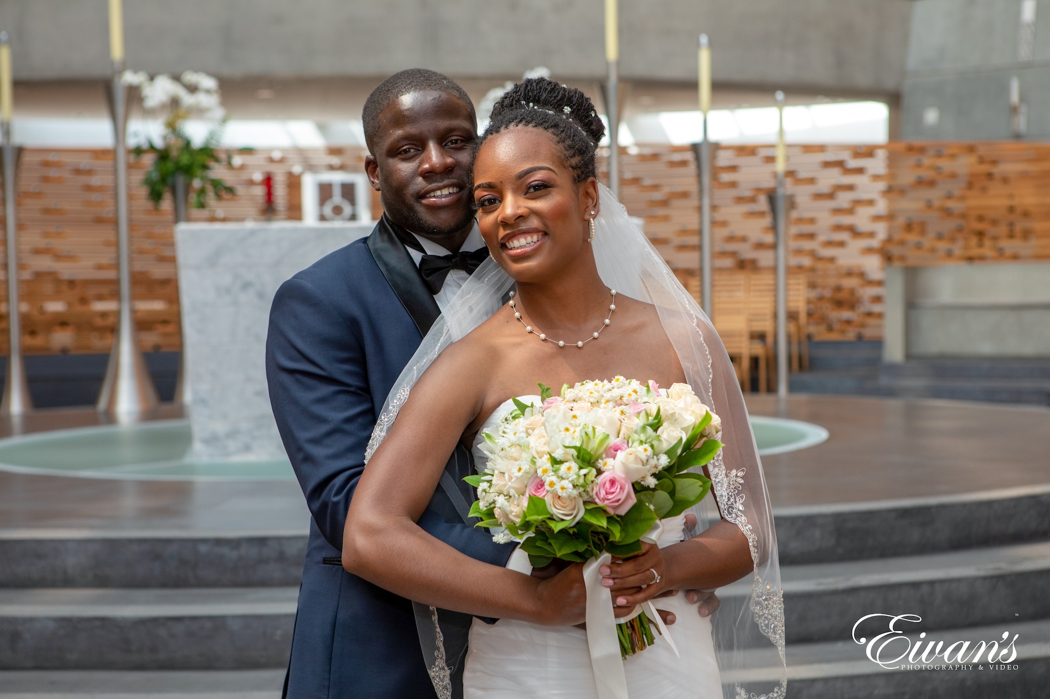 man in blue suit jacket holding bouquet of flowers