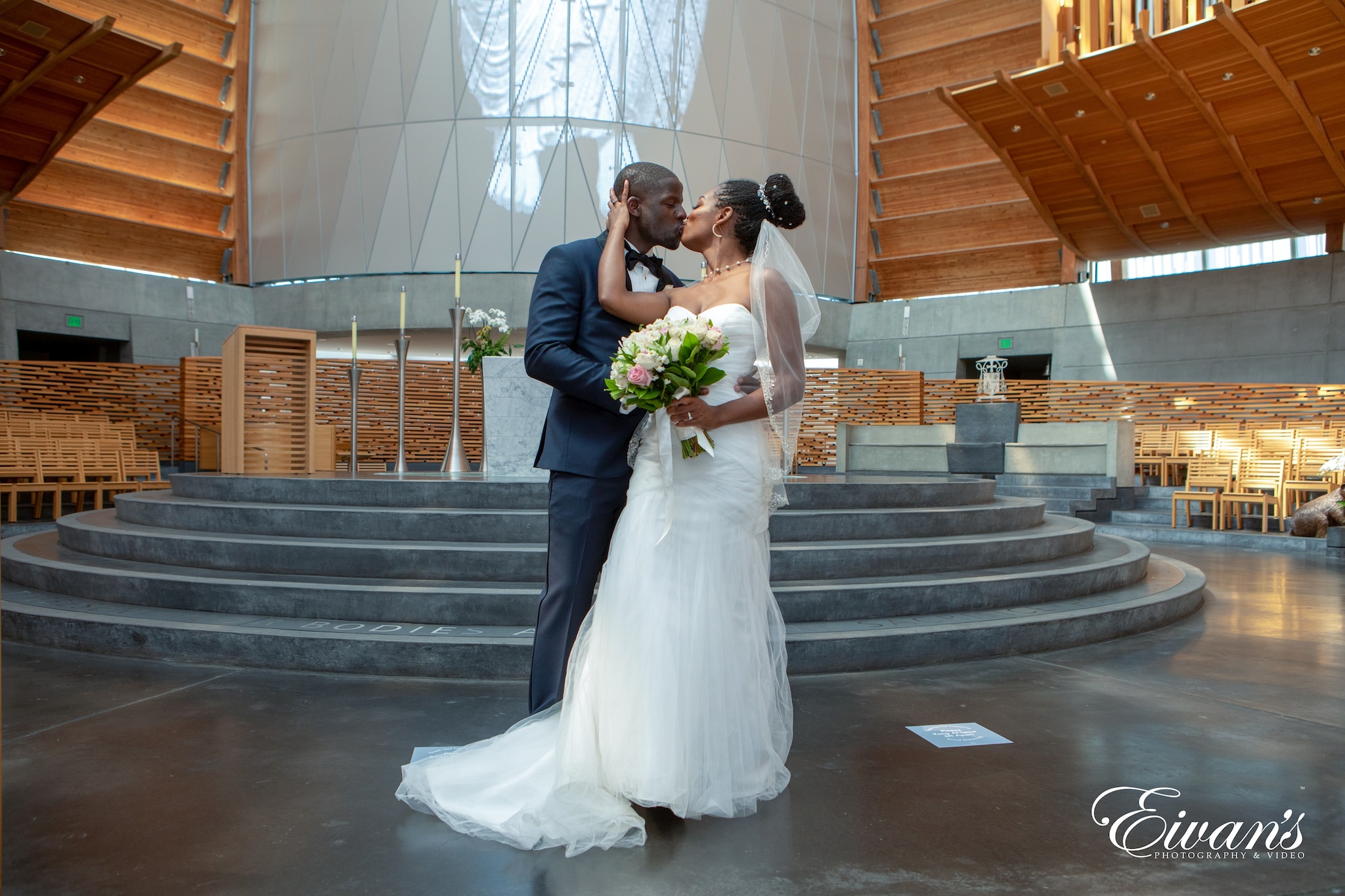 bride and groom kissing on gray concrete staircase