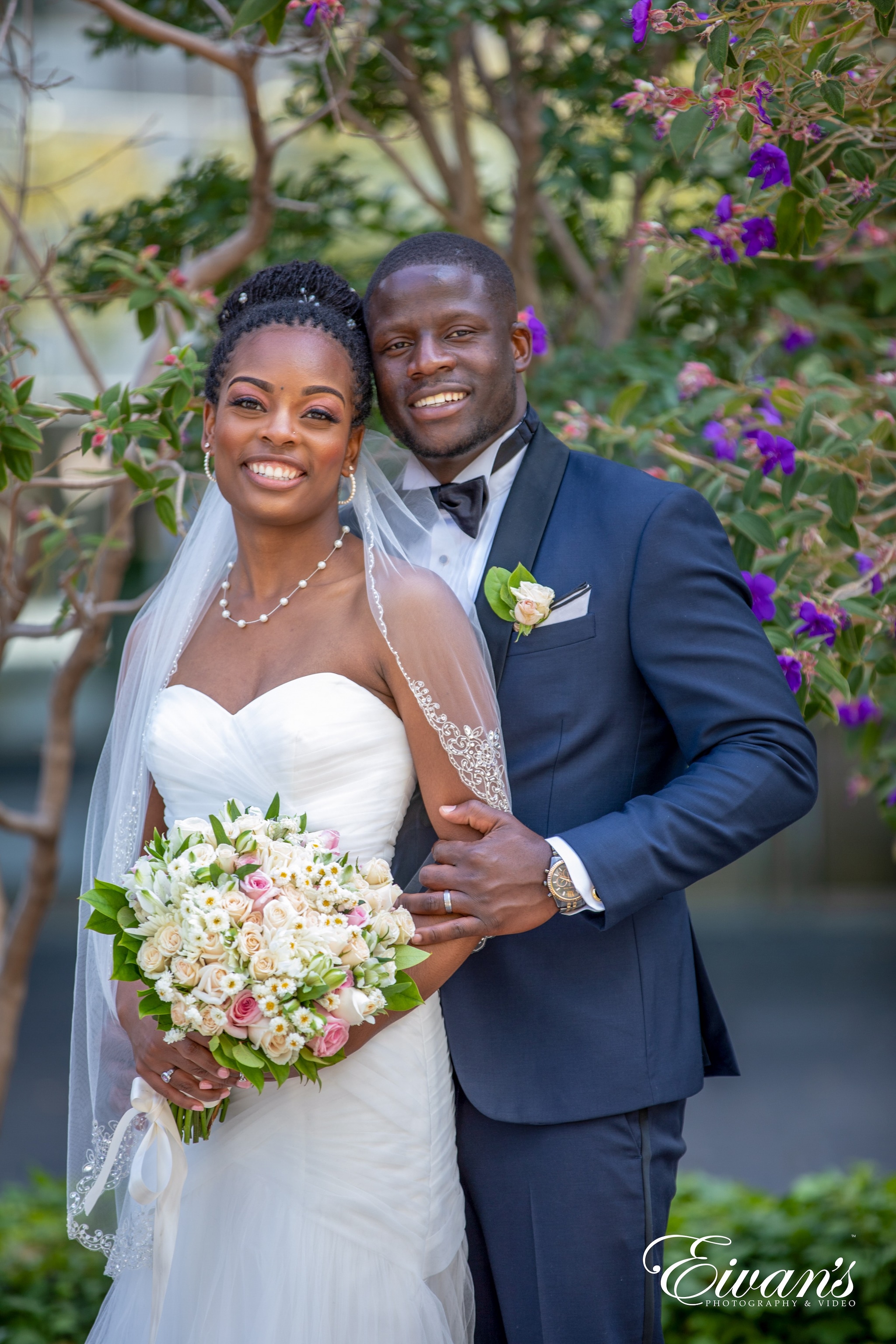 man in blue suit jacket hugging woman in white wedding dress