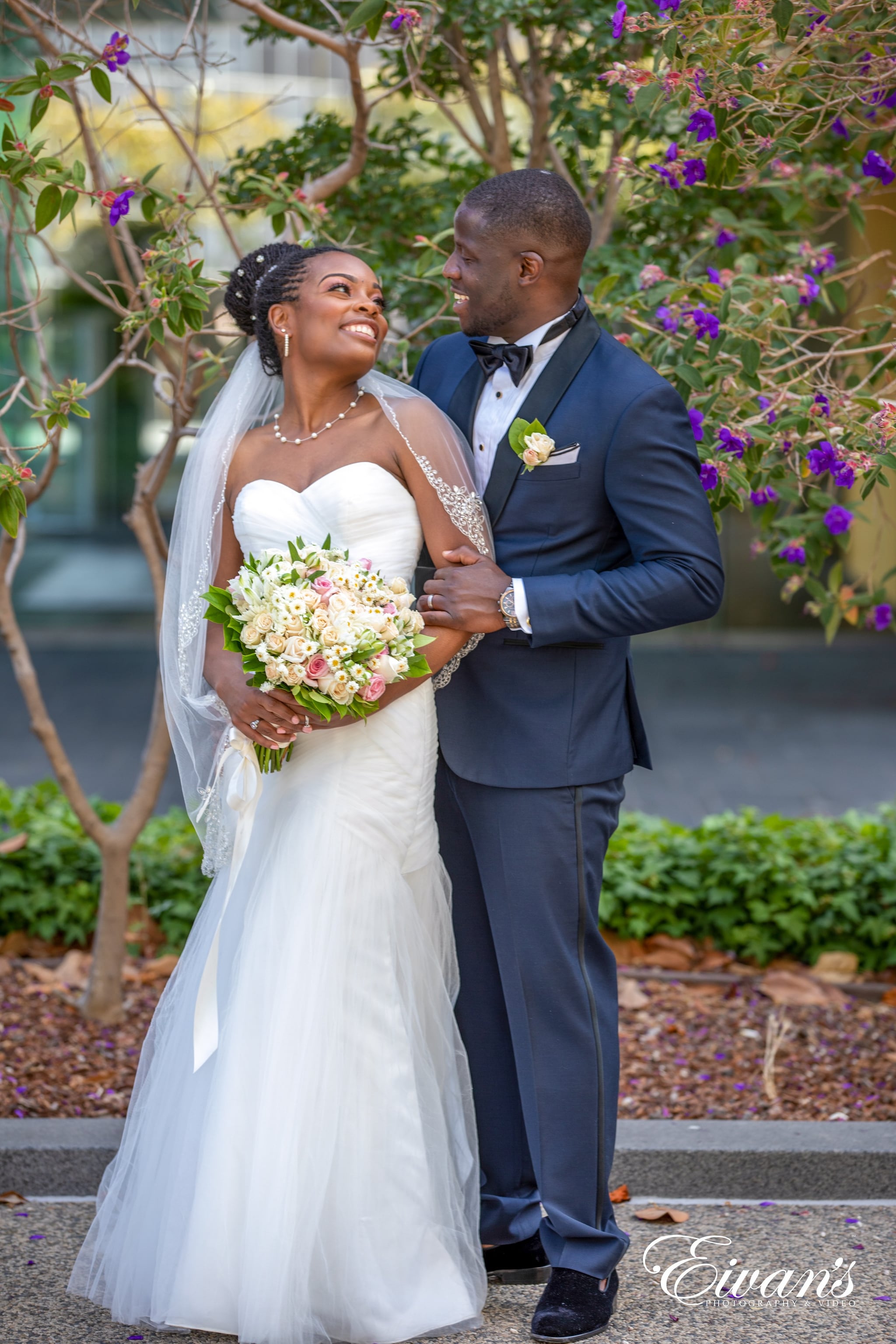 man in black suit and woman in white wedding dress