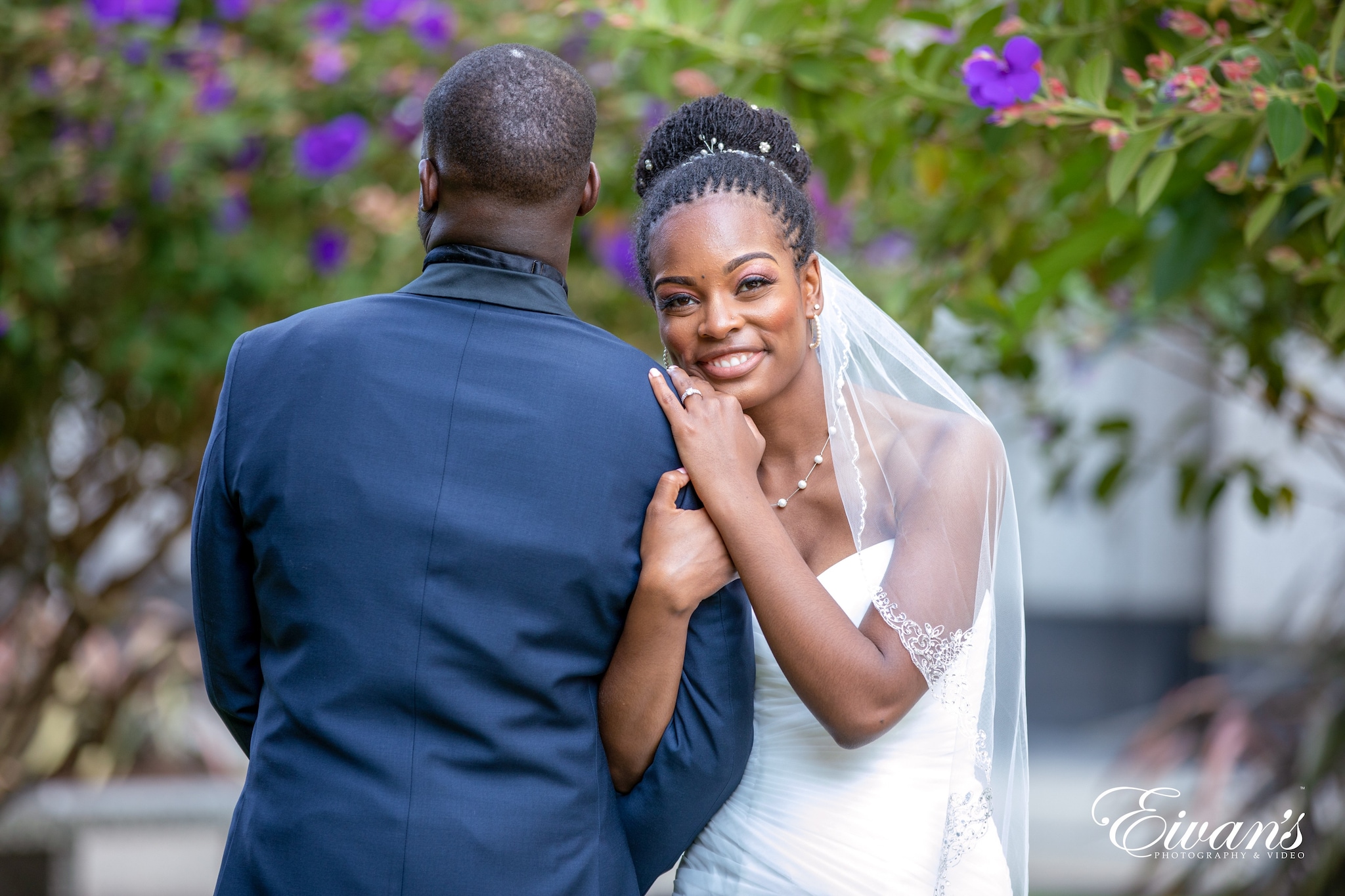man in blue suit kissing woman in white wedding dress
