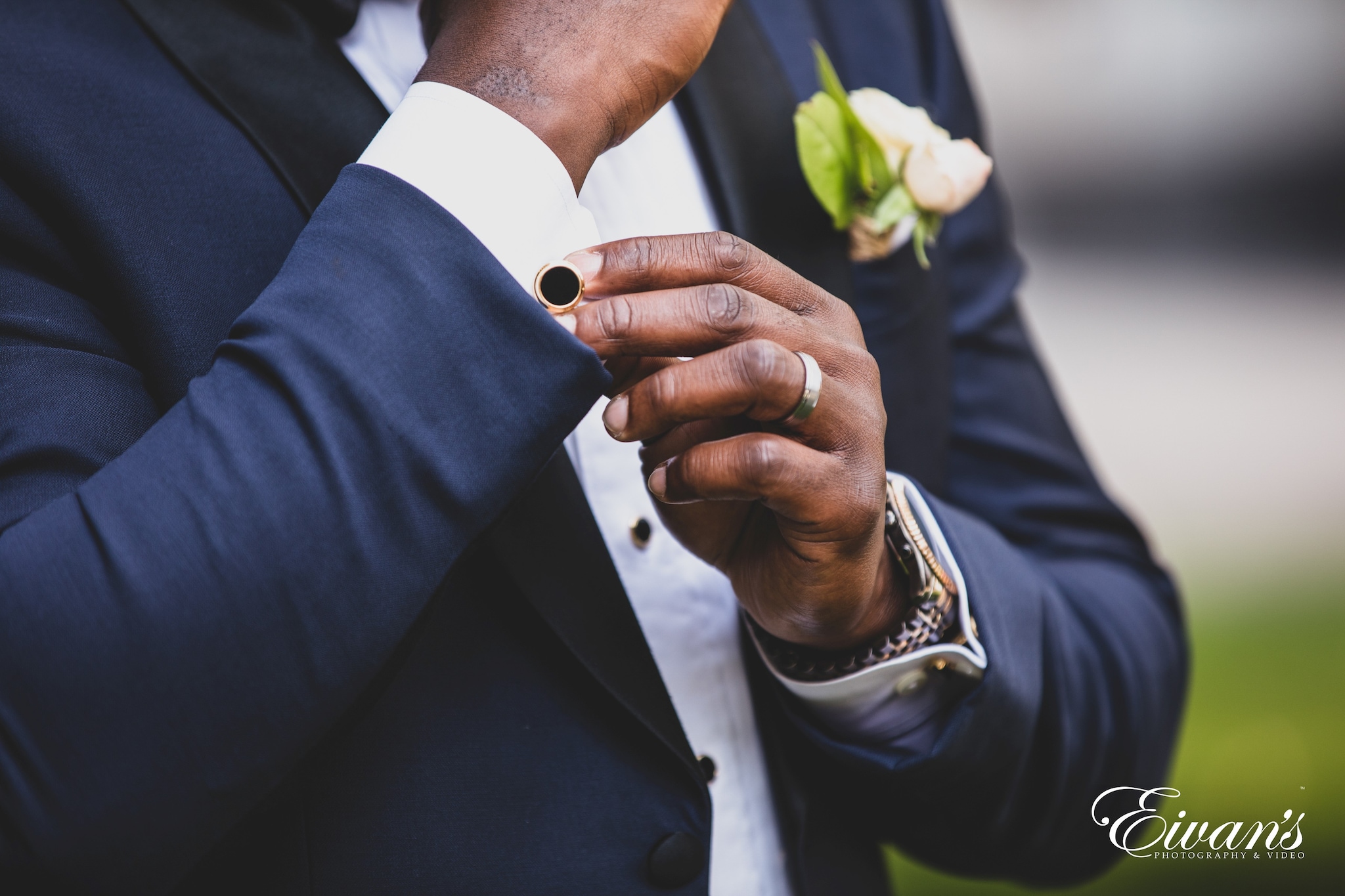 man in blue suit holding white flower bouquet