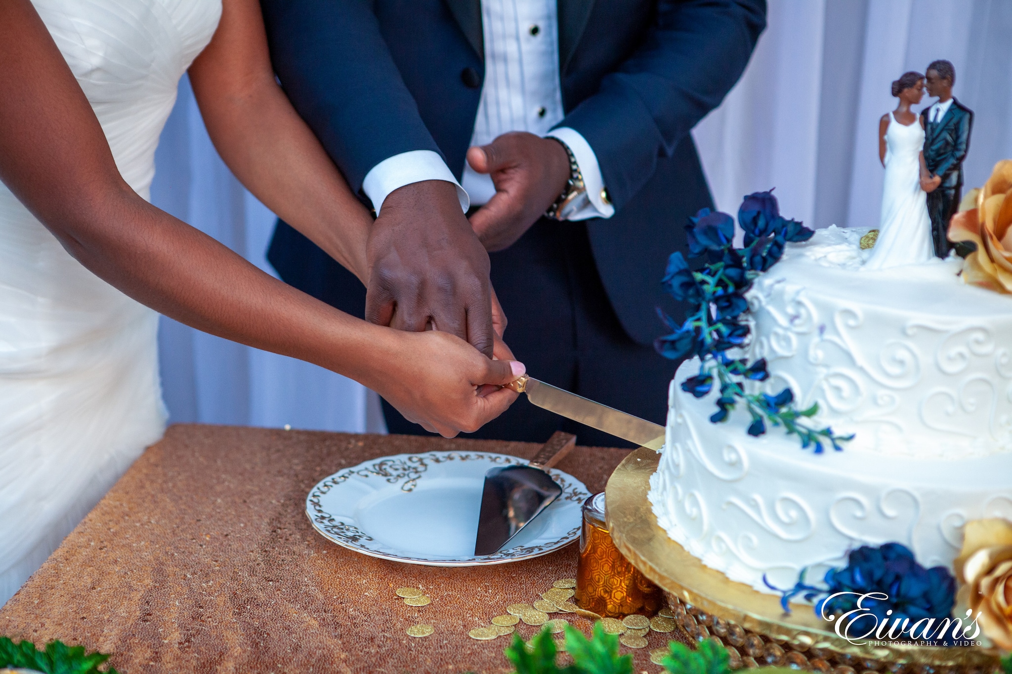 man in blue vest and white dress shirt holding knife slicing cake
