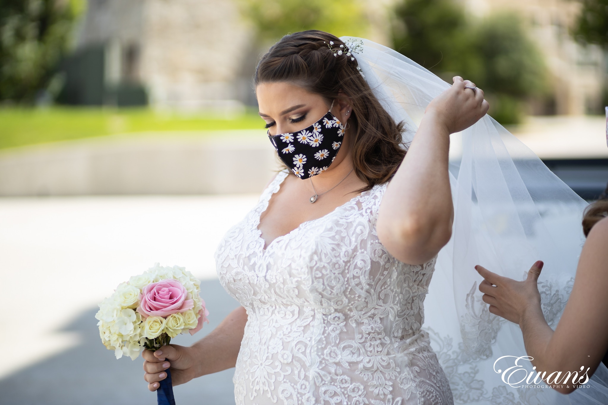 woman in white floral dress holding bouquet of flowers