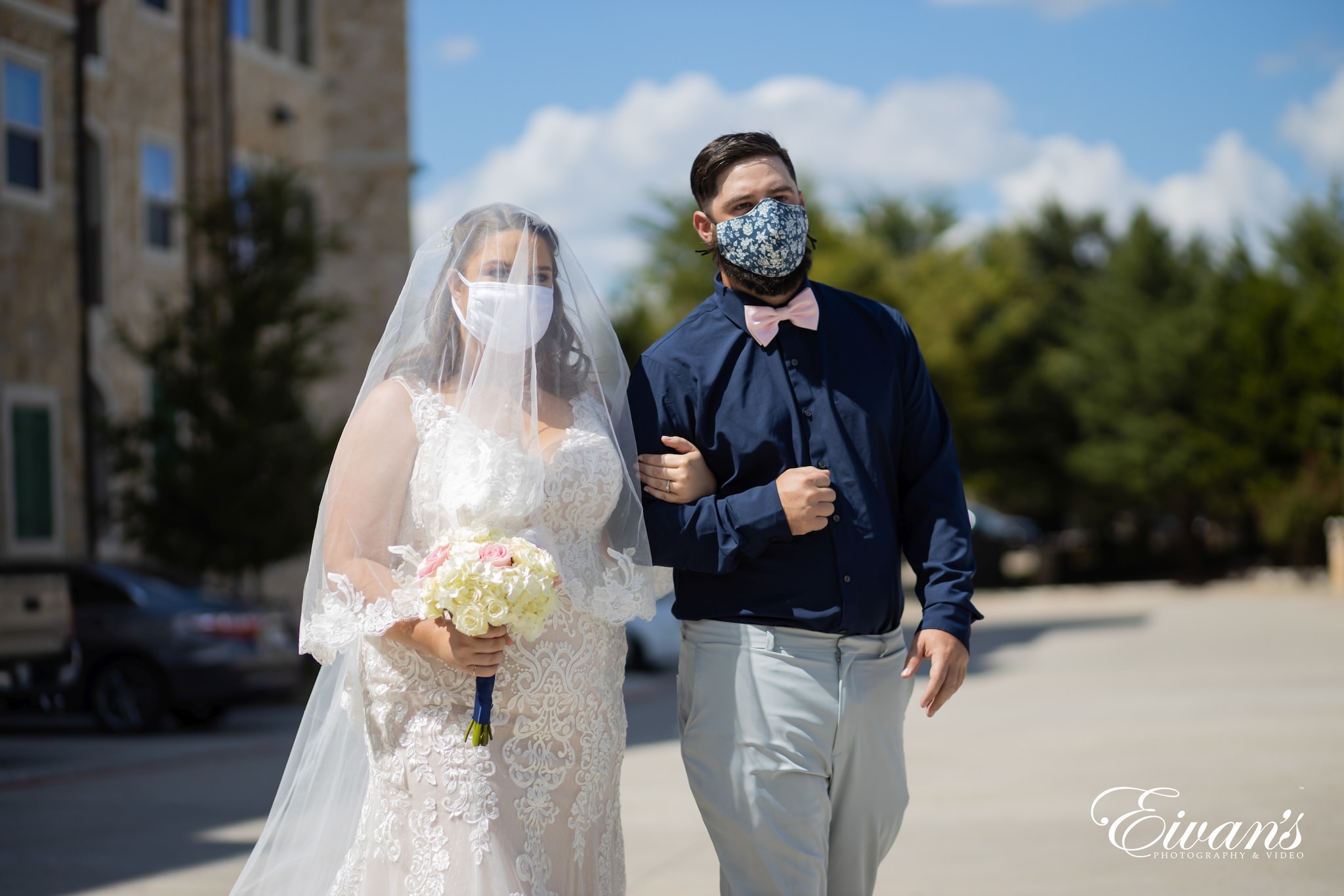 man in black long sleeve shirt holding woman in white wedding dress during daytime