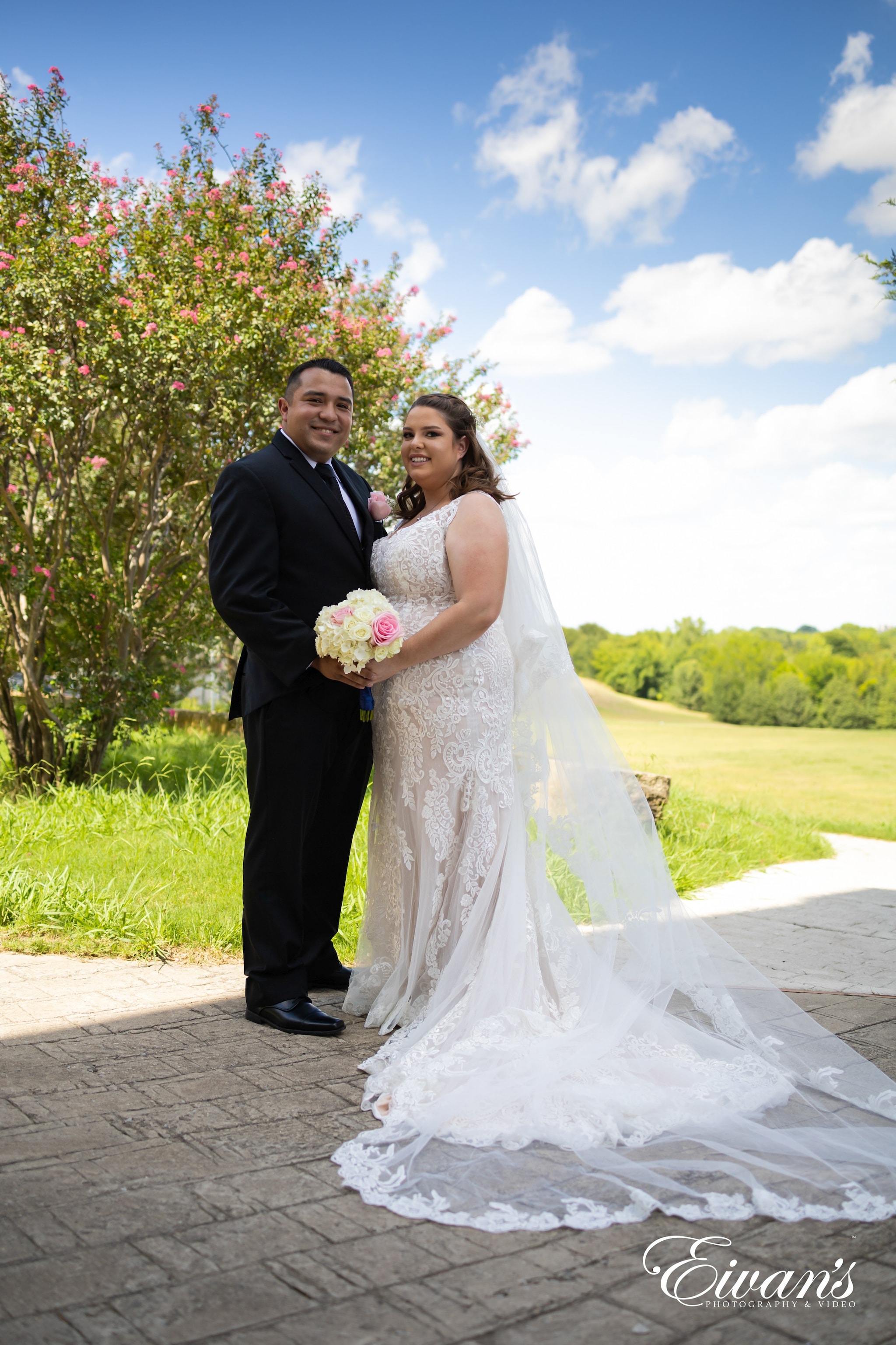 bride and groom standing on pathway between green grass field during daytime