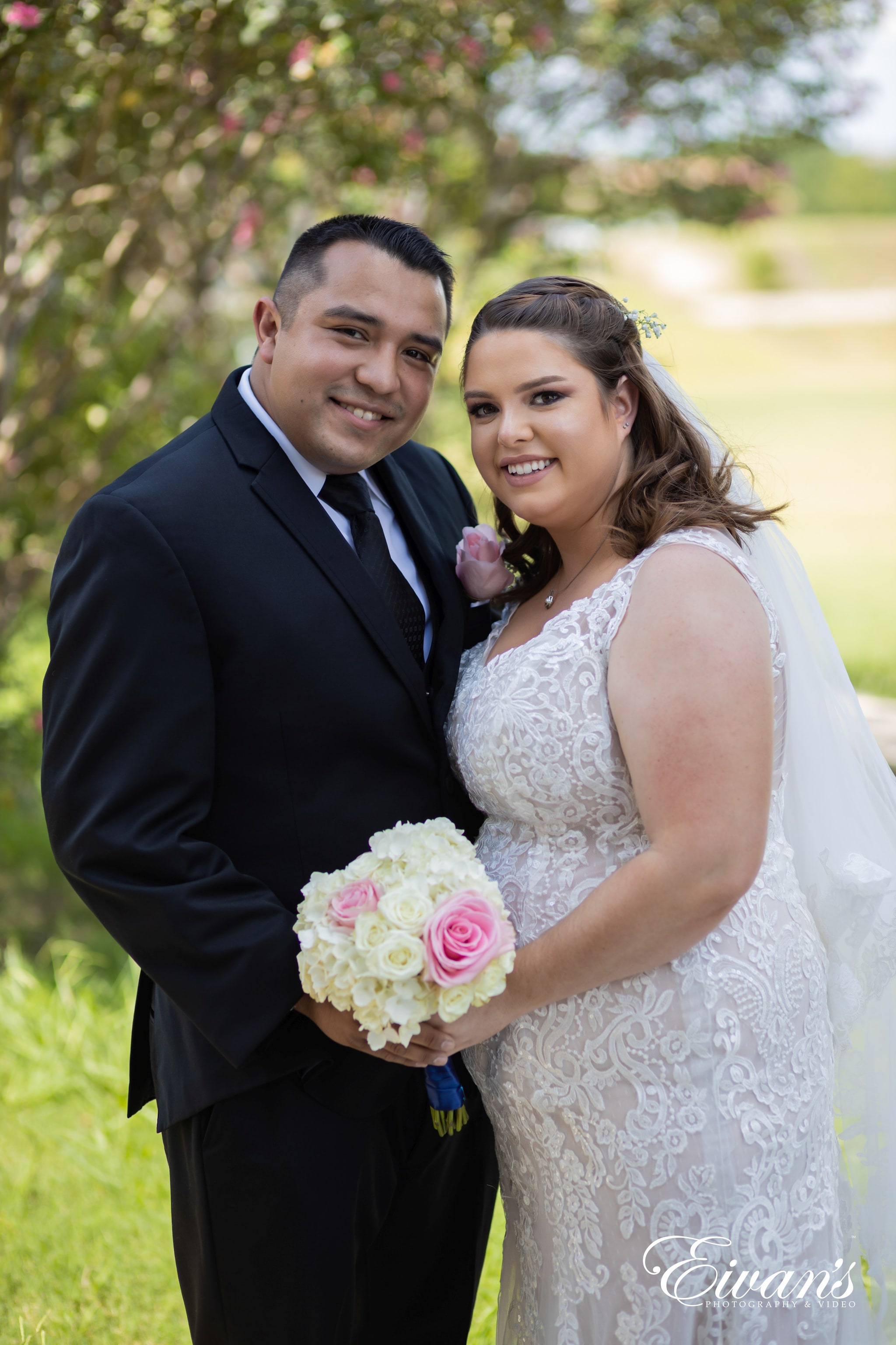 man in black suit holding a bouquet of flowers