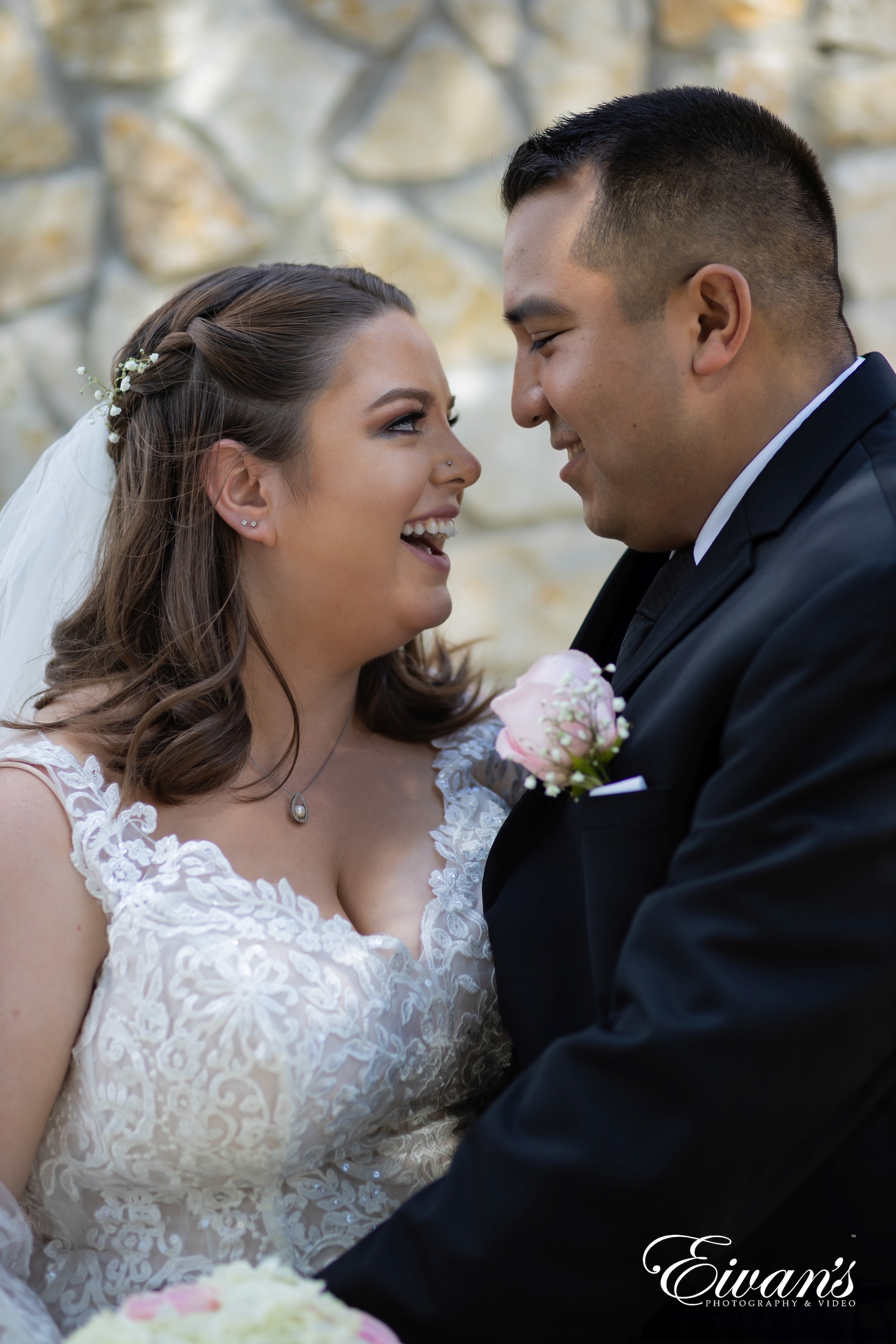 man in black suit kissing woman in white floral wedding dress