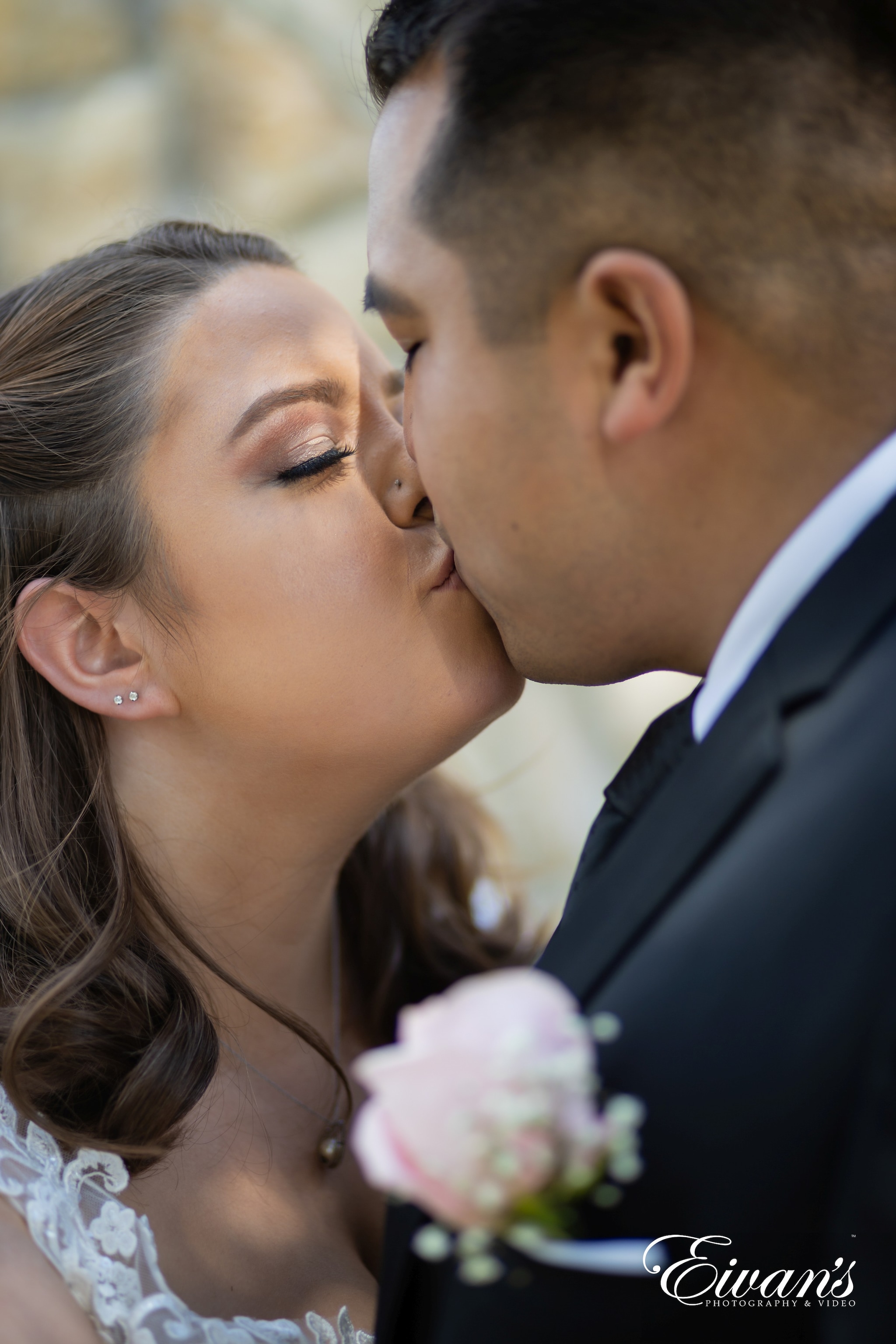 man in black suit kissing womans cheek