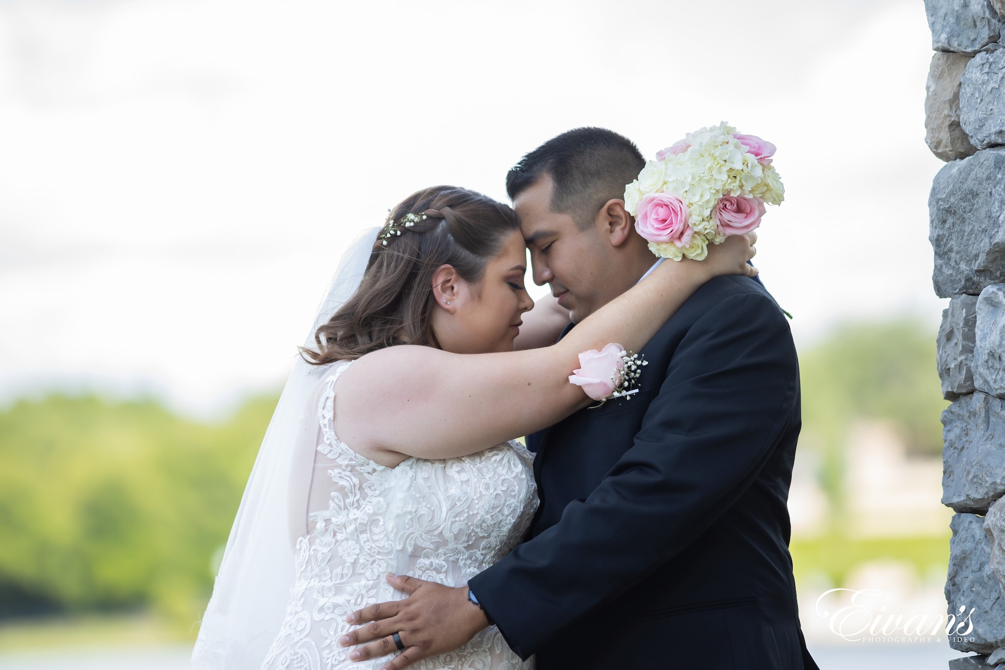 man in black suit kissing woman in white wedding dress