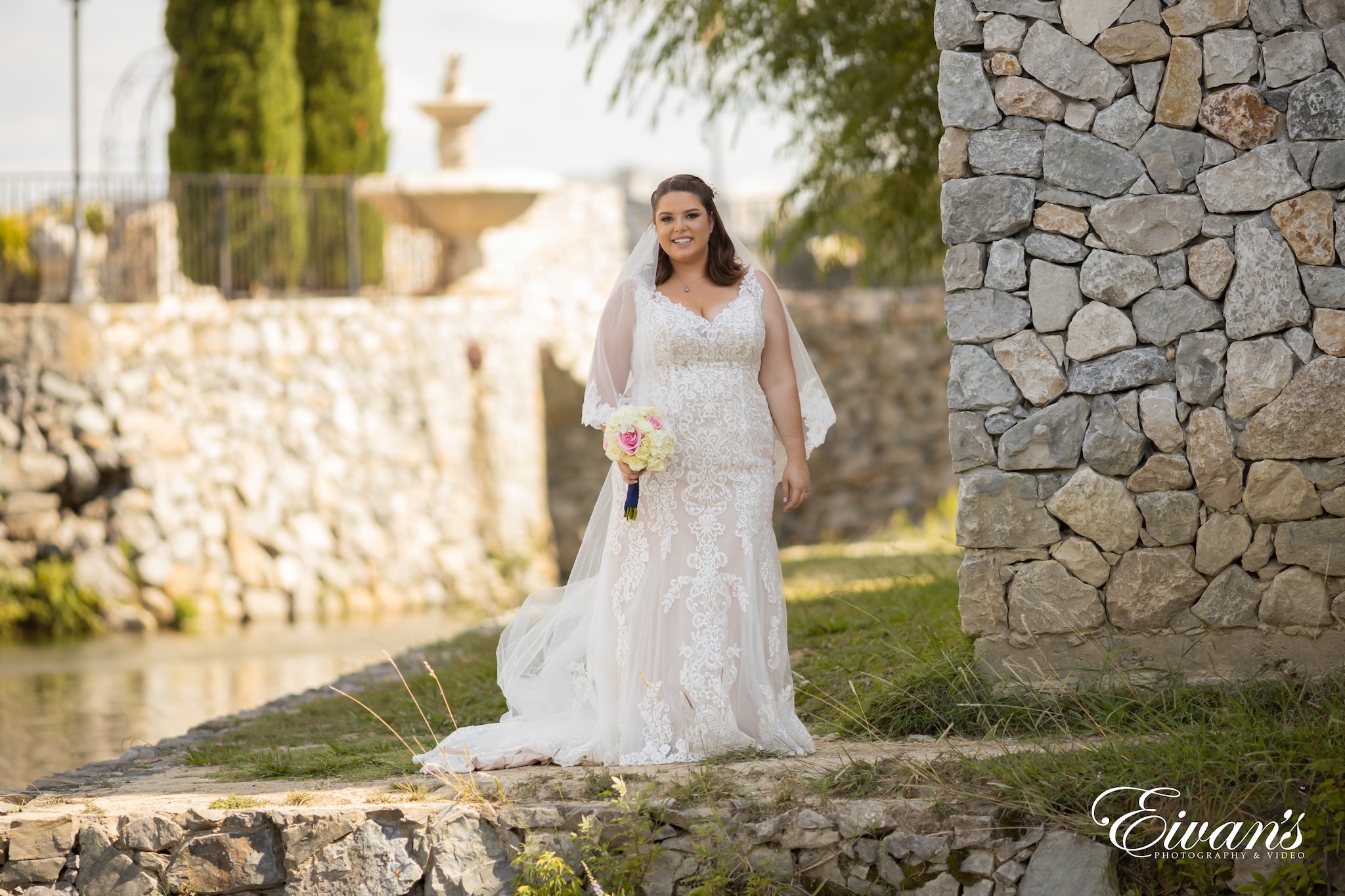woman in white wedding dress standing on green grass field during daytime