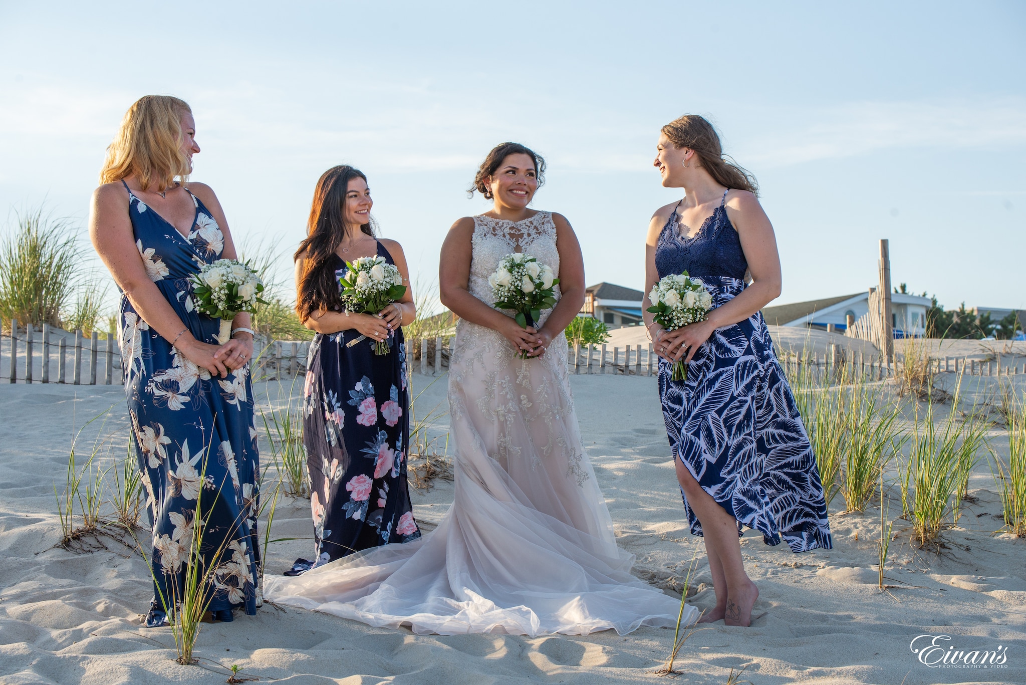 woman in white wedding gown standing beside woman in blue and white floral dress