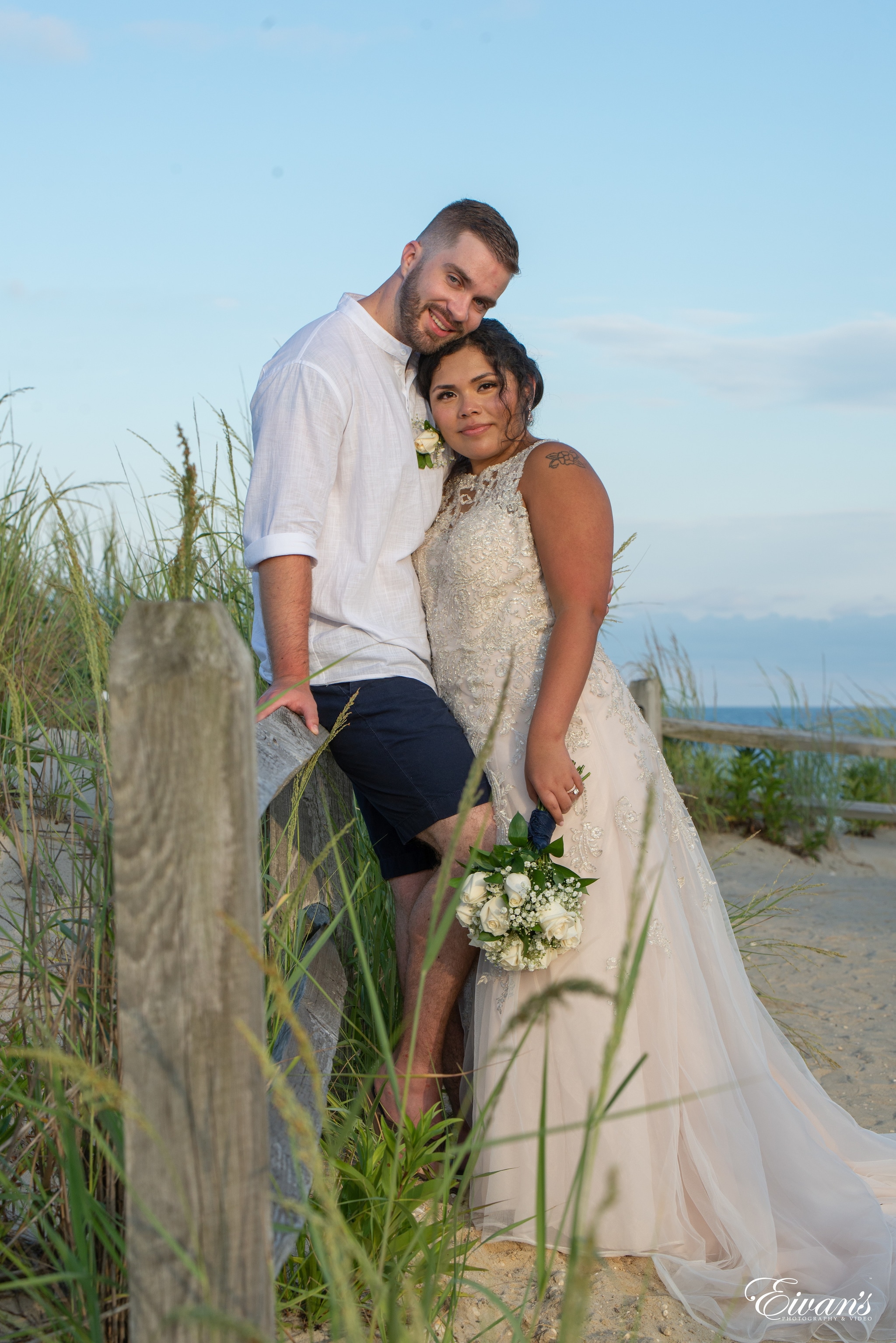 man in white dress shirt and woman in white wedding dress holding bouquet of flowers