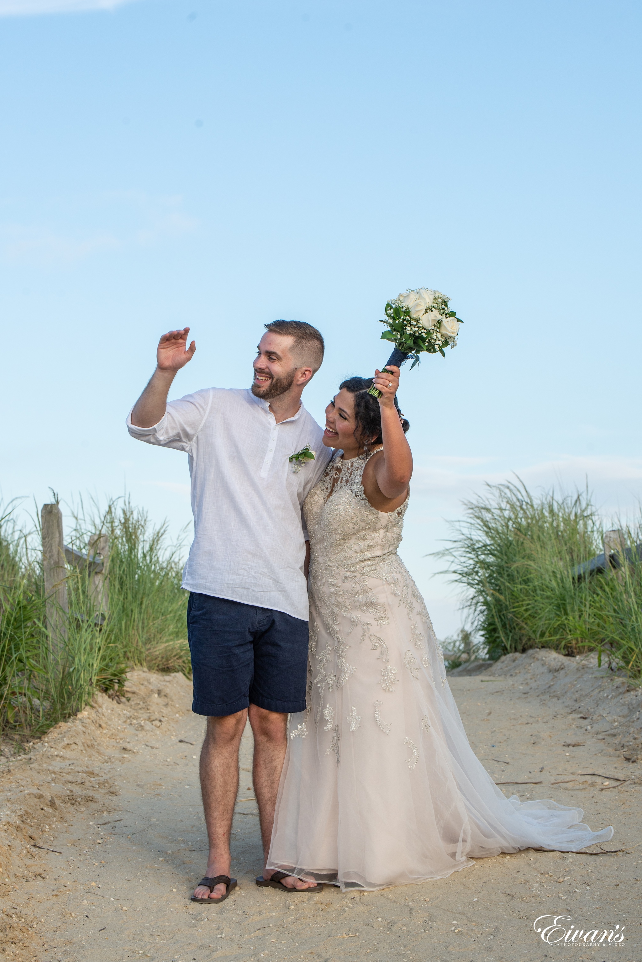 man and woman holding hands while walking on beach during daytime