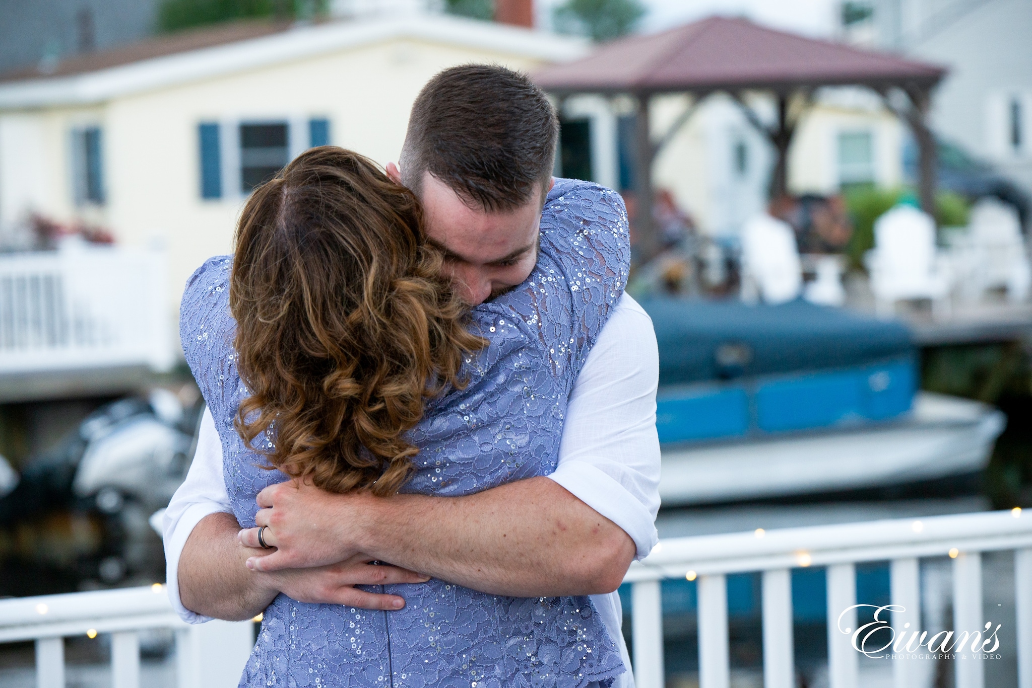 man in white dress shirt hugging woman in blue dress