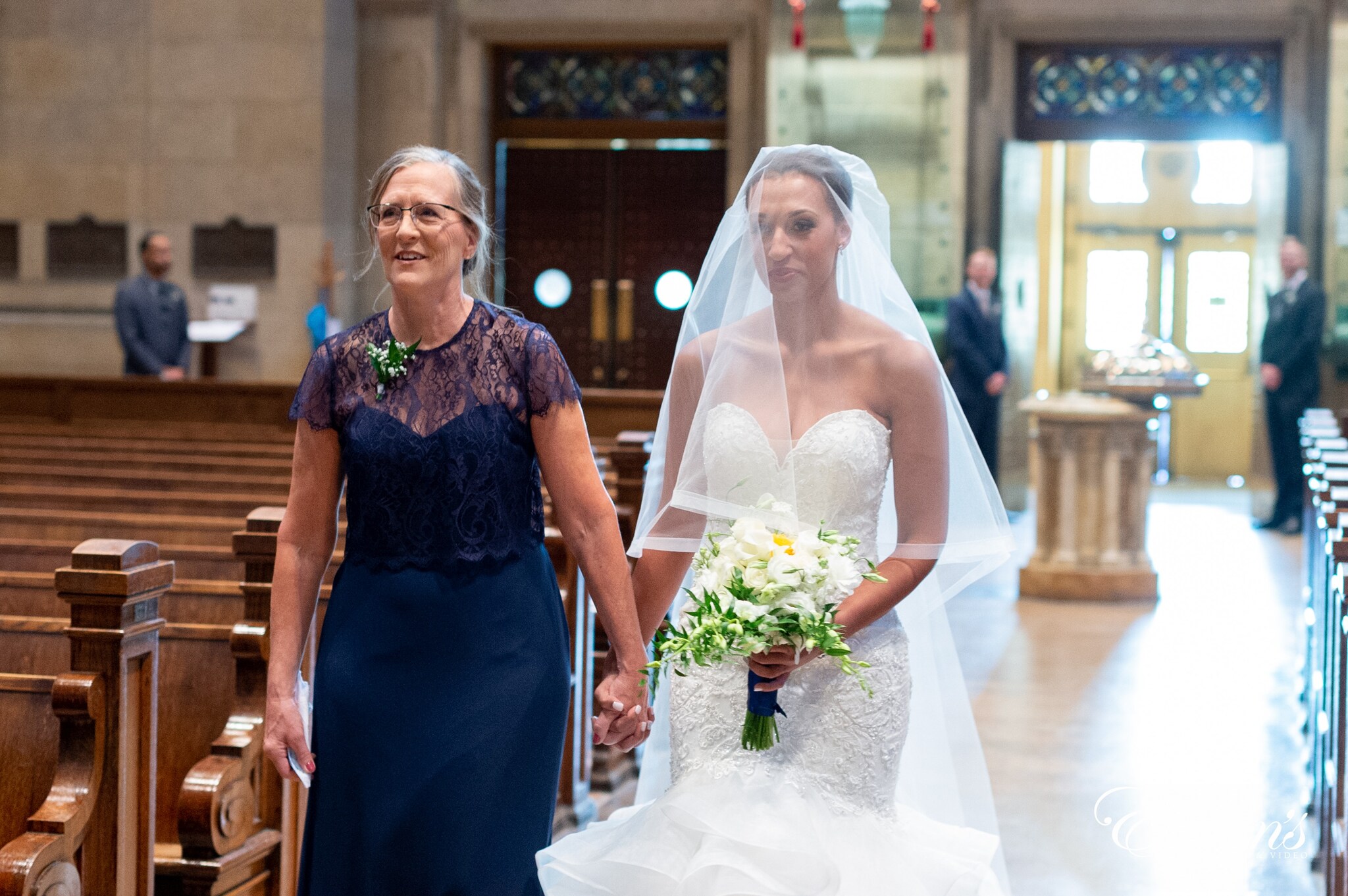 woman in blue floral dress holding bouquet of flowers