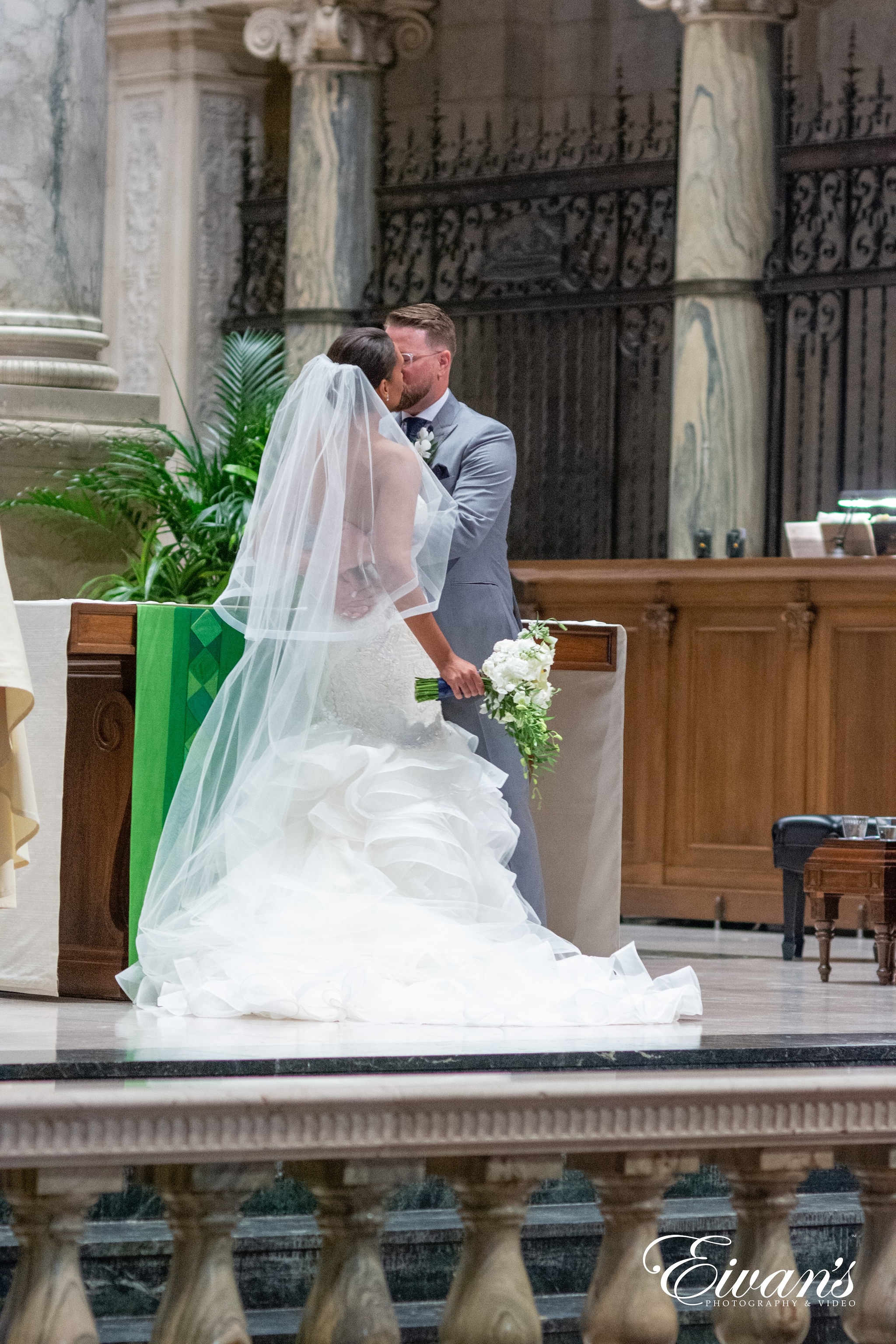 bride and groom sitting on brown wooden bench