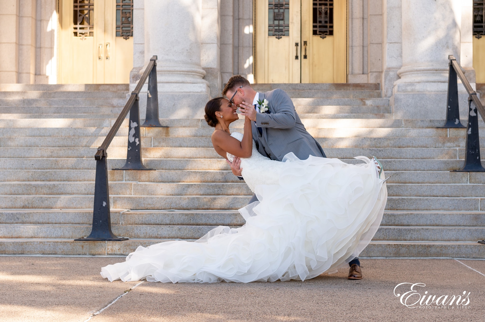 woman in white wedding gown kissing man in black suit