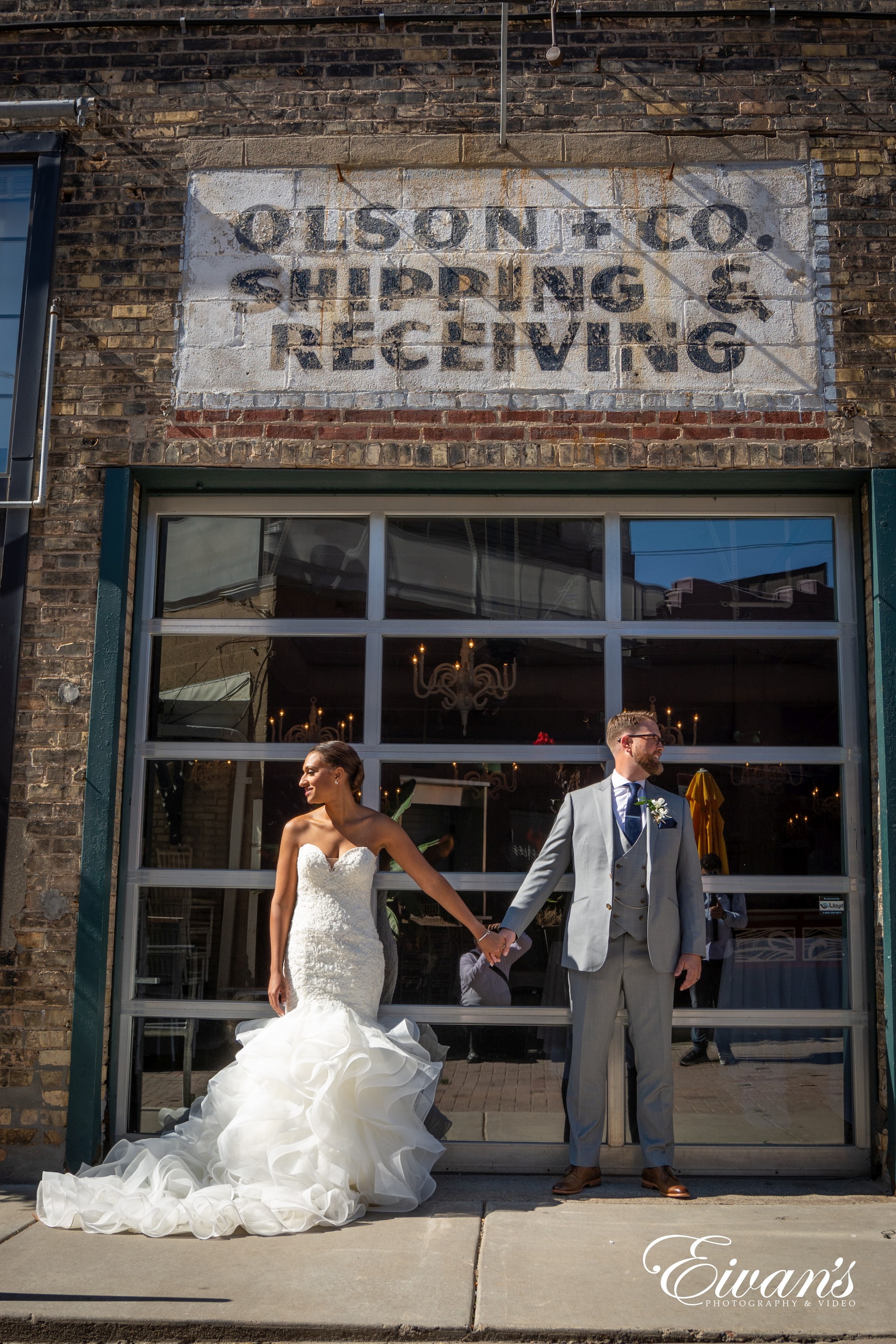 man in gray suit jacket standing beside woman in white wedding gown