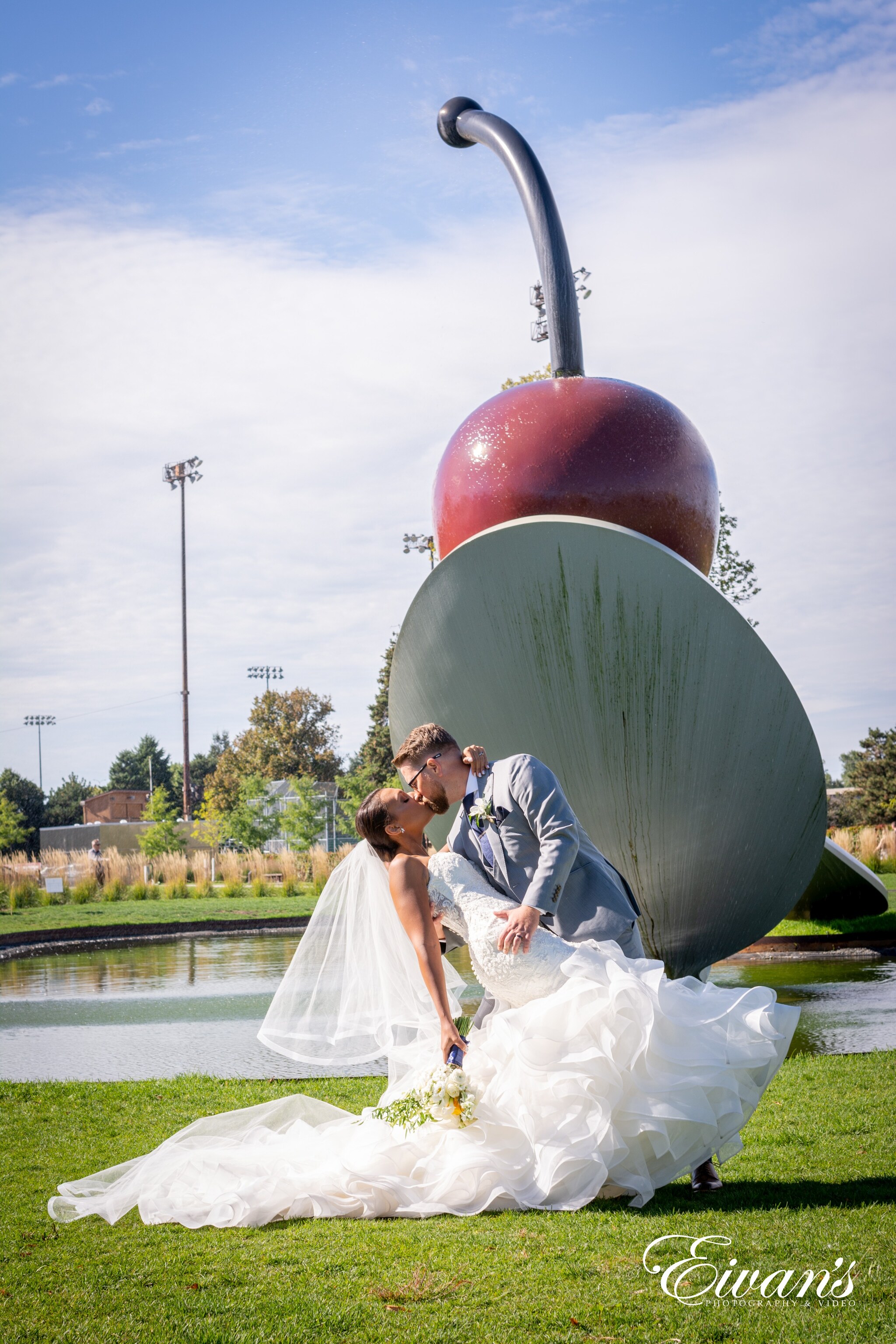 man and woman kissing on red ball near body of water during daytime