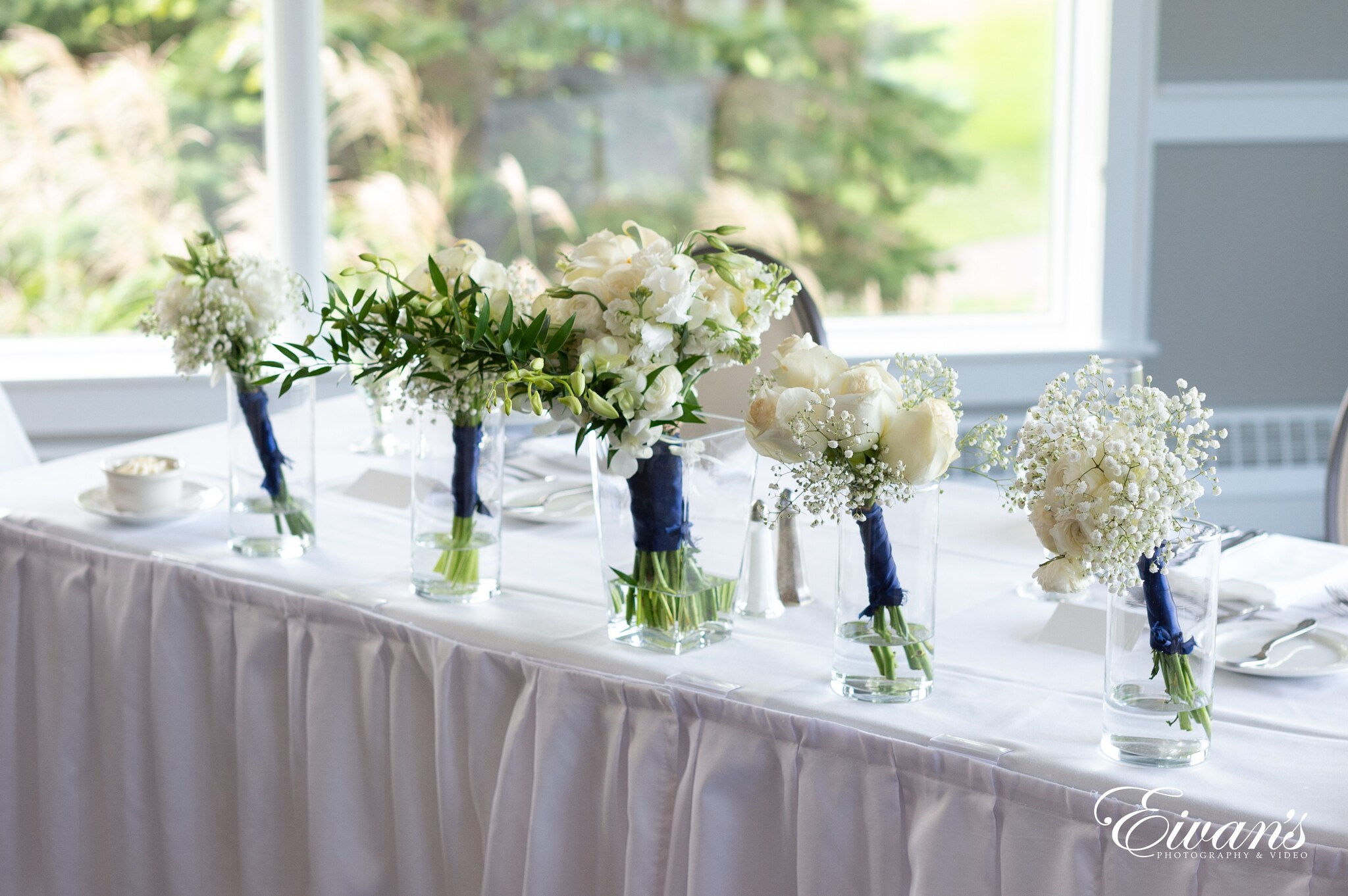 white roses in clear glass vase on white table