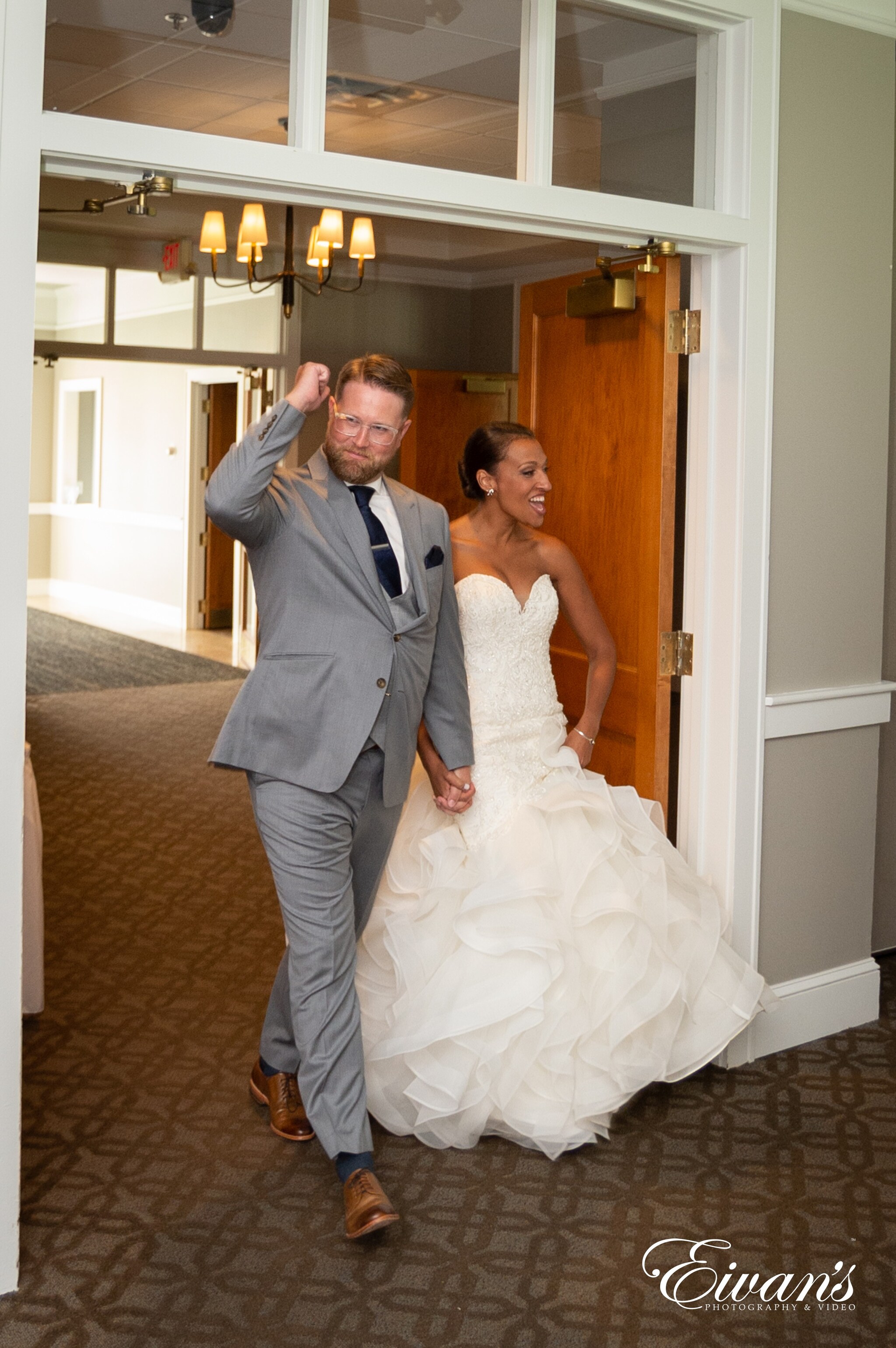 man in gray suit jacket hugging woman in white wedding gown