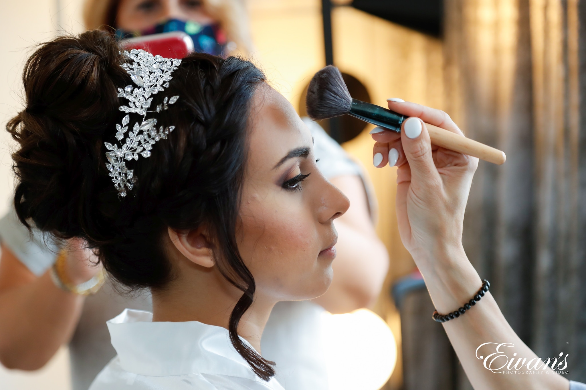 woman in white shirt holding makeup brush