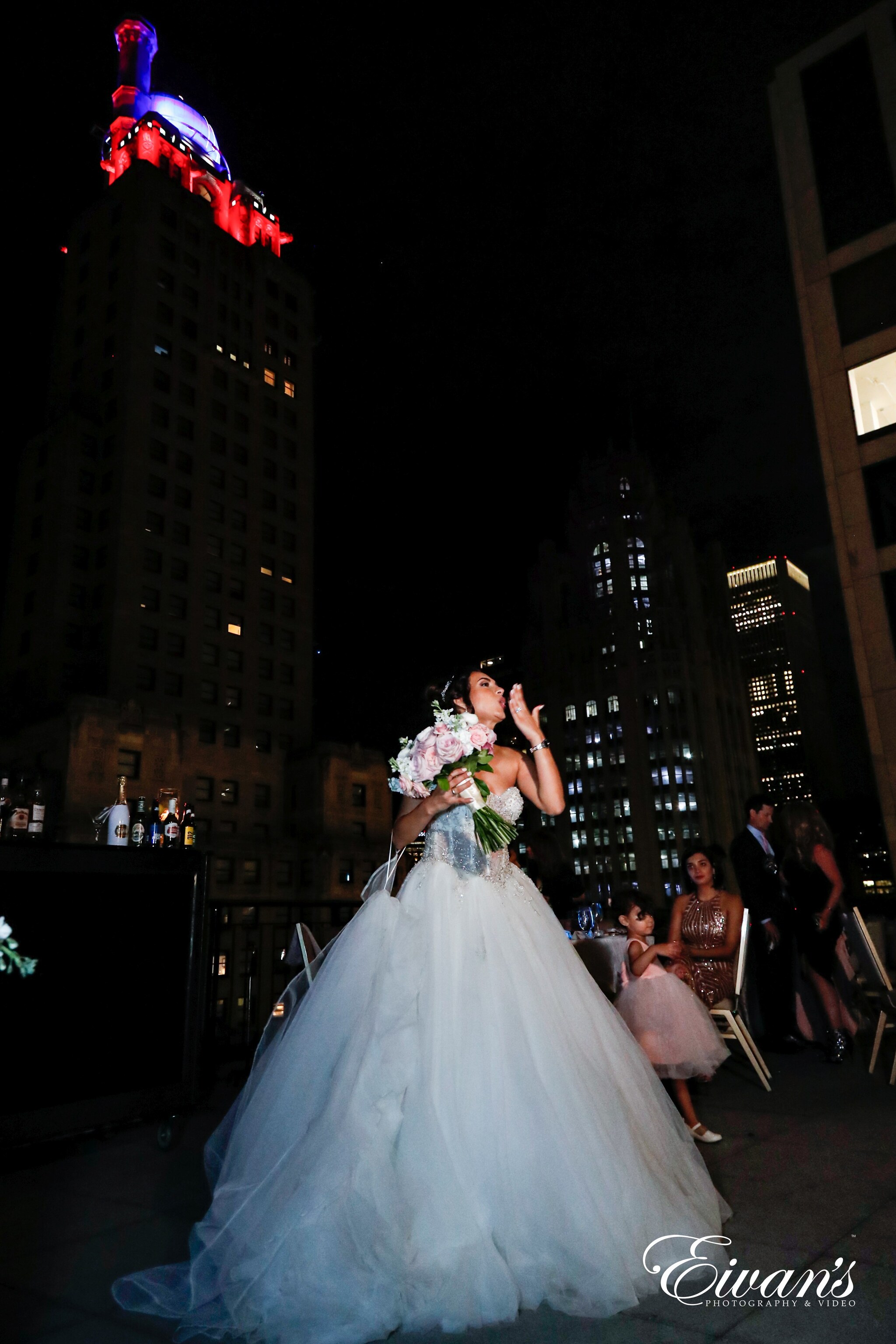 woman in white wedding gown standing on the street during nighttime
