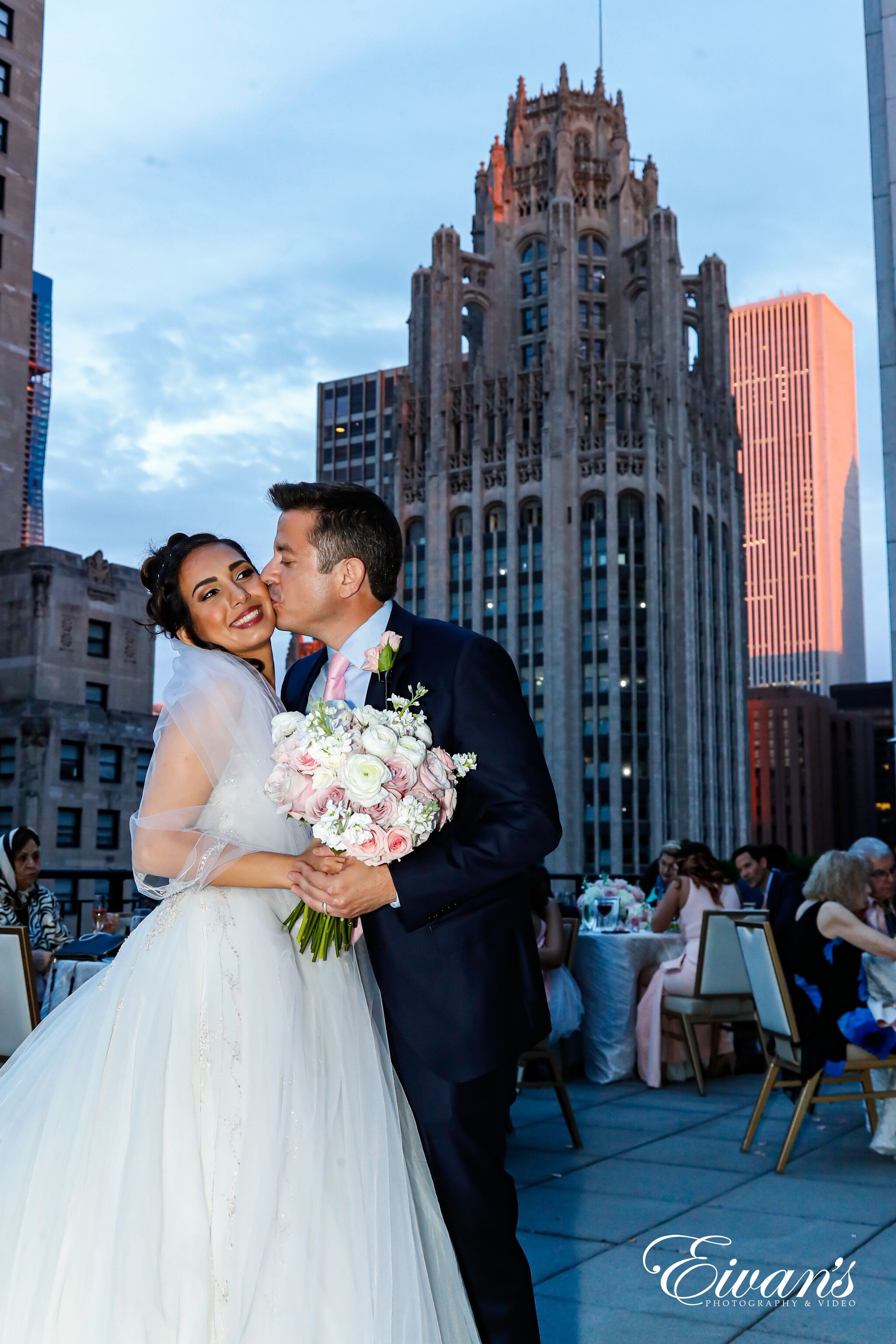 man in black suit kissing woman in white wedding dress