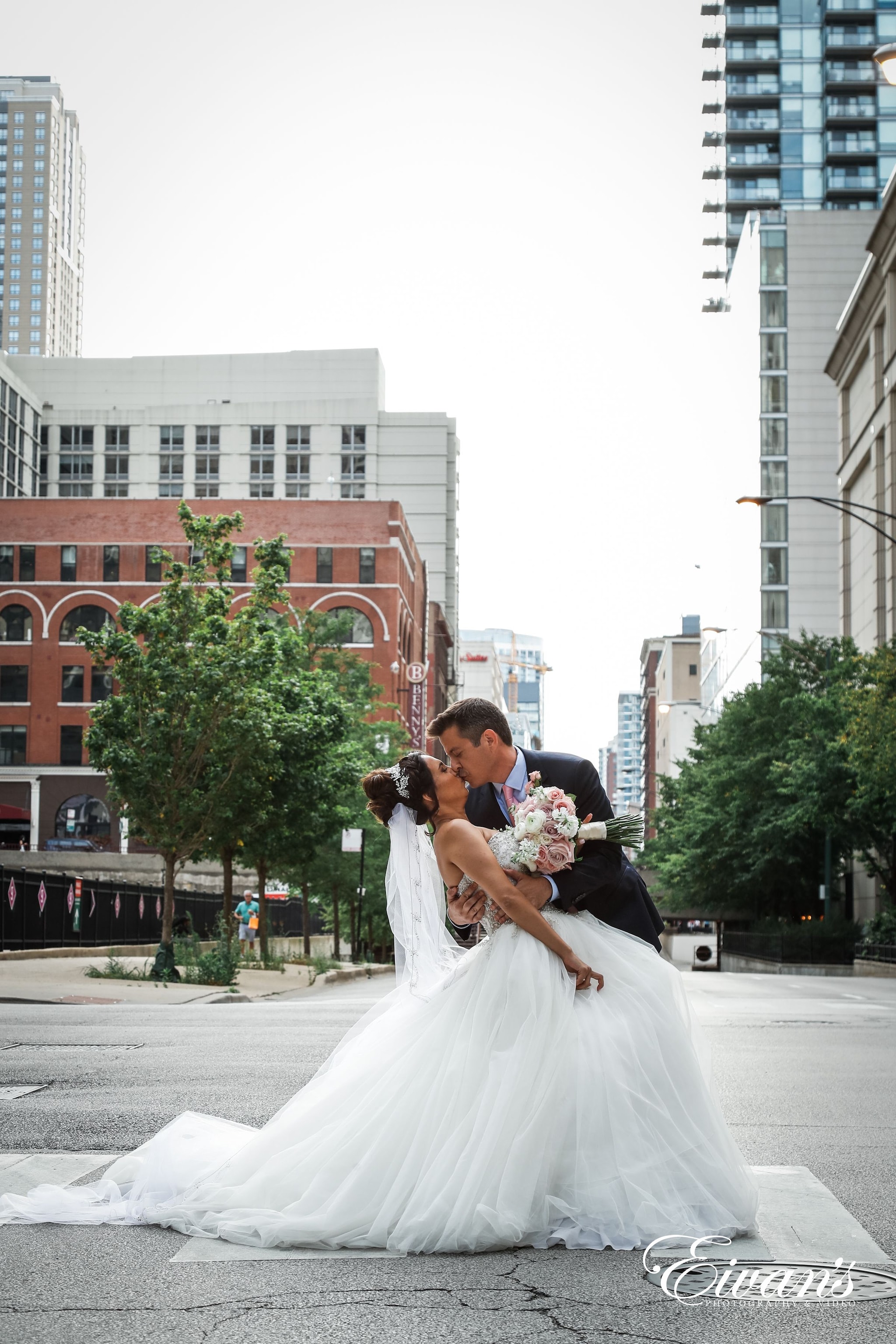 bride and groom kissing on the street during daytime