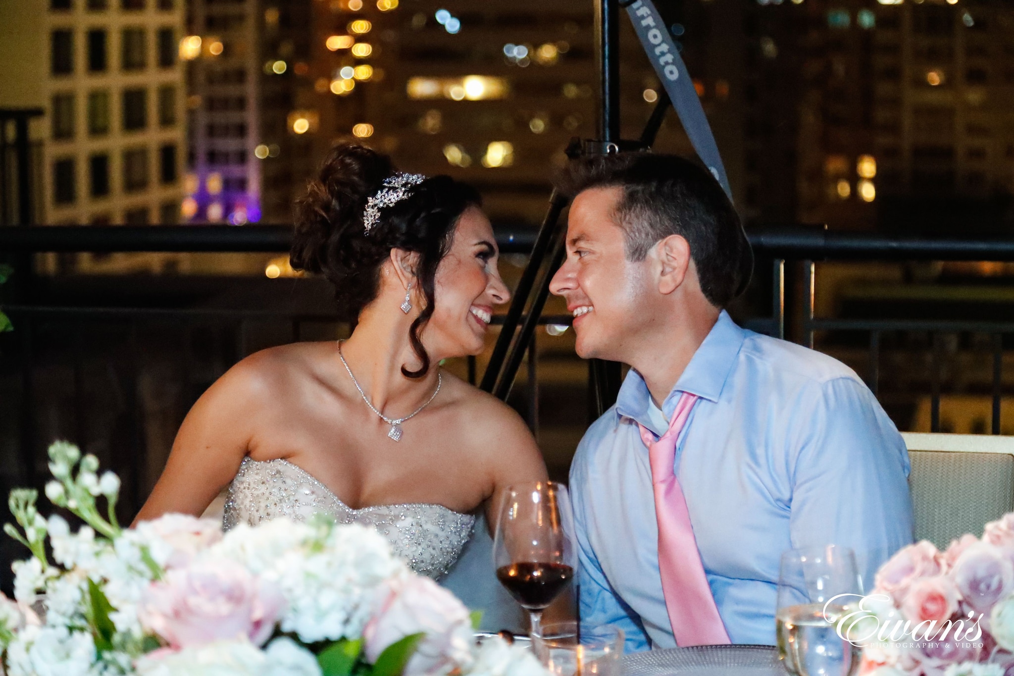 man in blue dress shirt sitting beside woman in white wedding dress