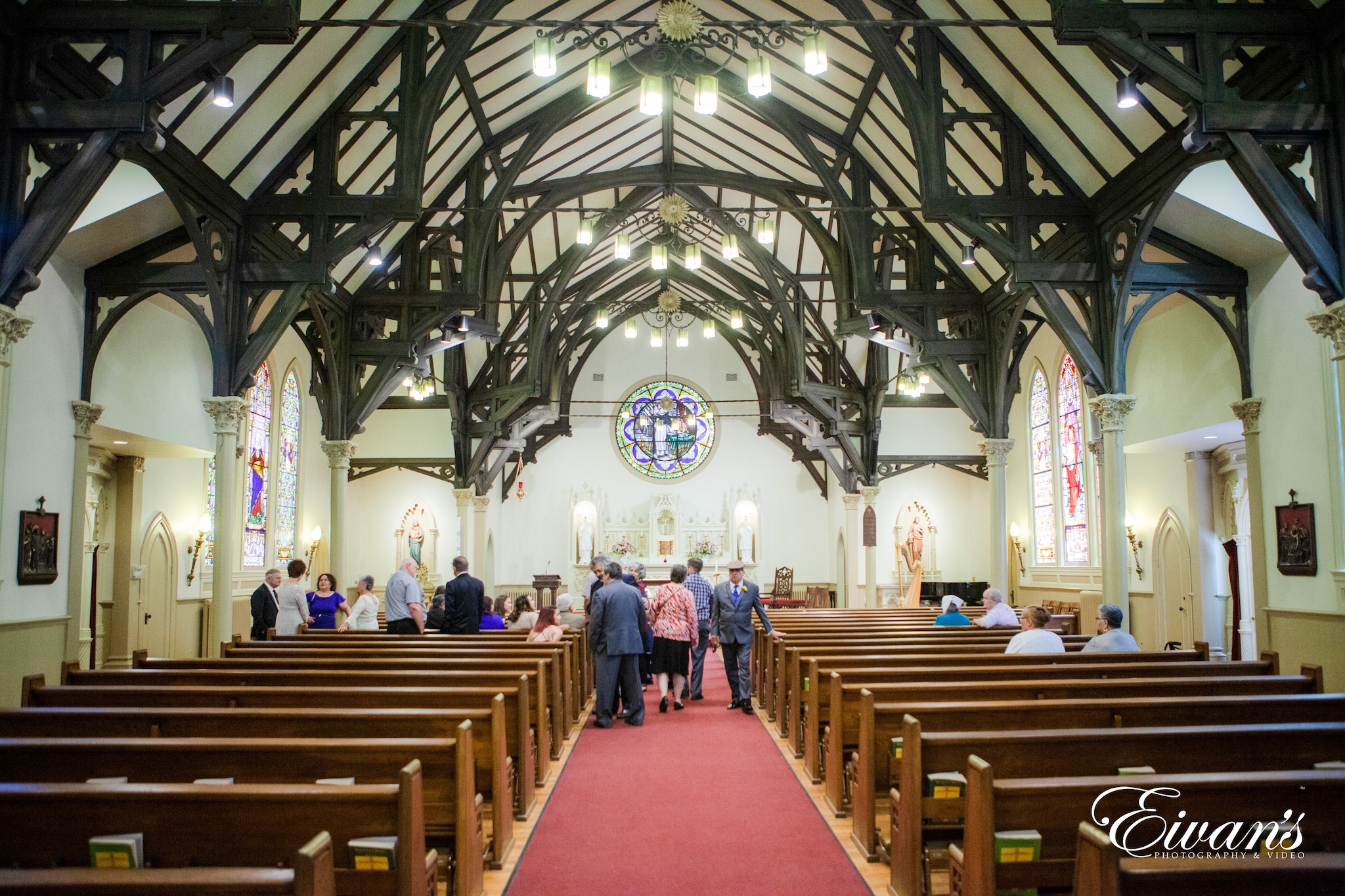 people sitting on brown wooden bench inside cathedral