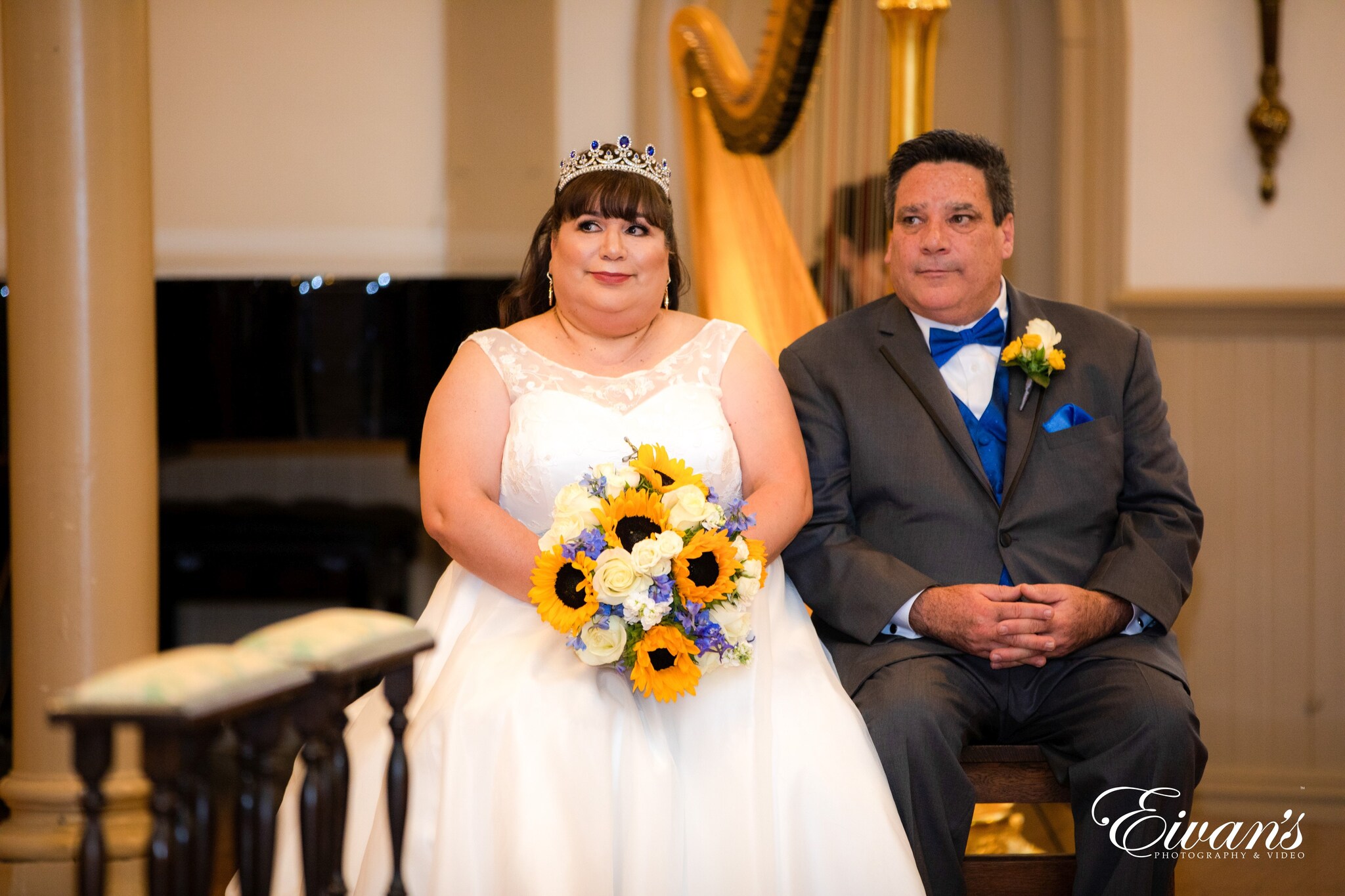 man in black suit sitting beside woman in white wedding dress
