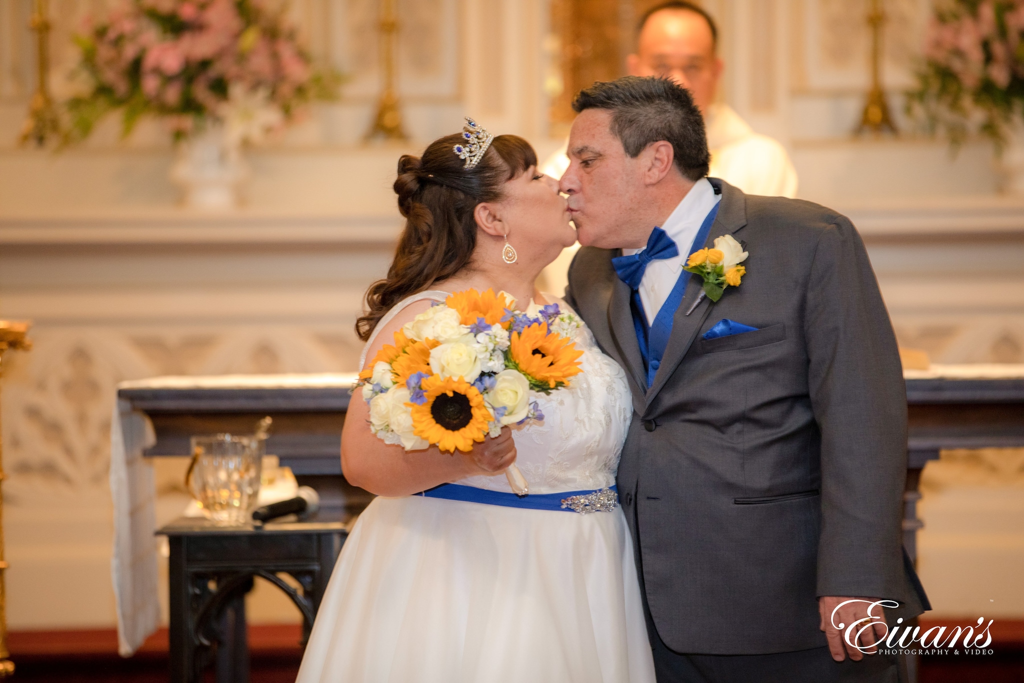 man in black suit jacket kissing woman in white wedding dress