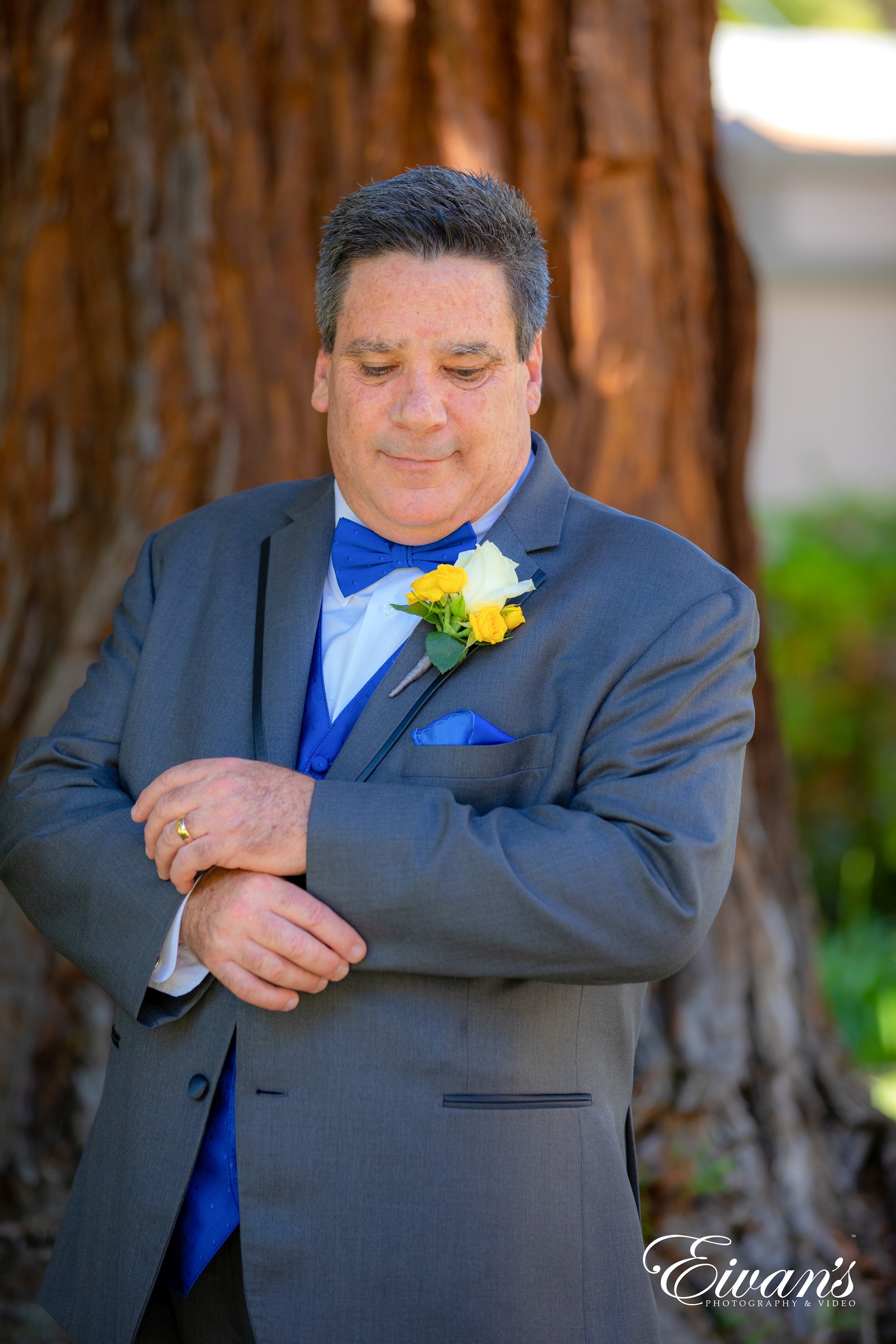 man in black suit jacket holding yellow flower